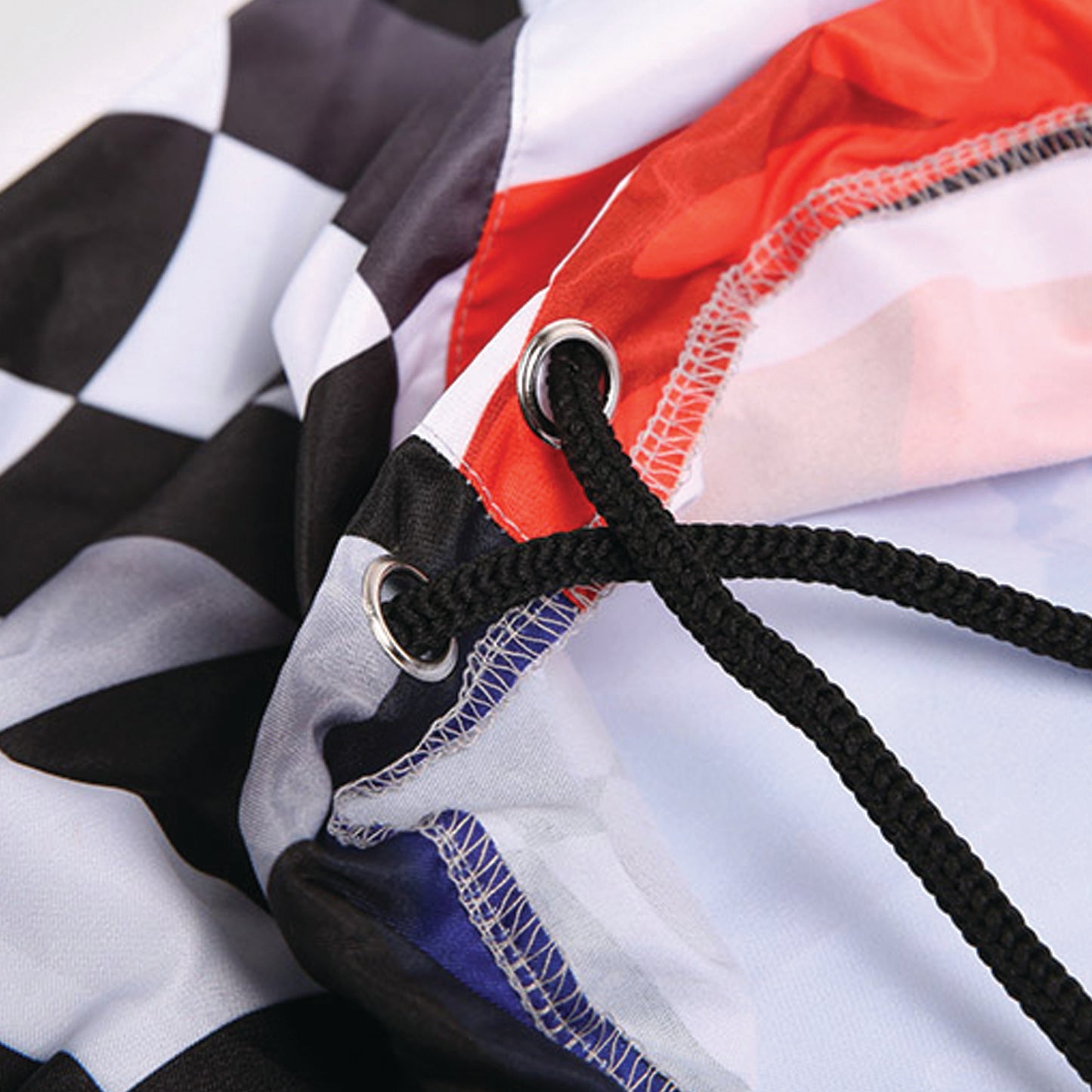 A close-up view of a colorful fabric with a checkered pattern, featuring a black and white checkered design and a red and white striped pattern.