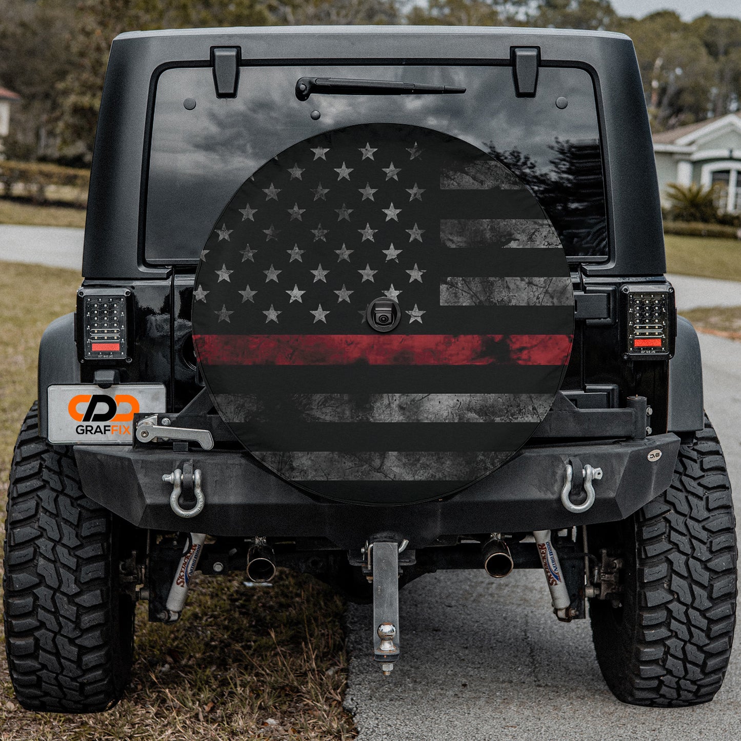 the back of a black Jeep Wrangler with a large American flag decal on the rear window.