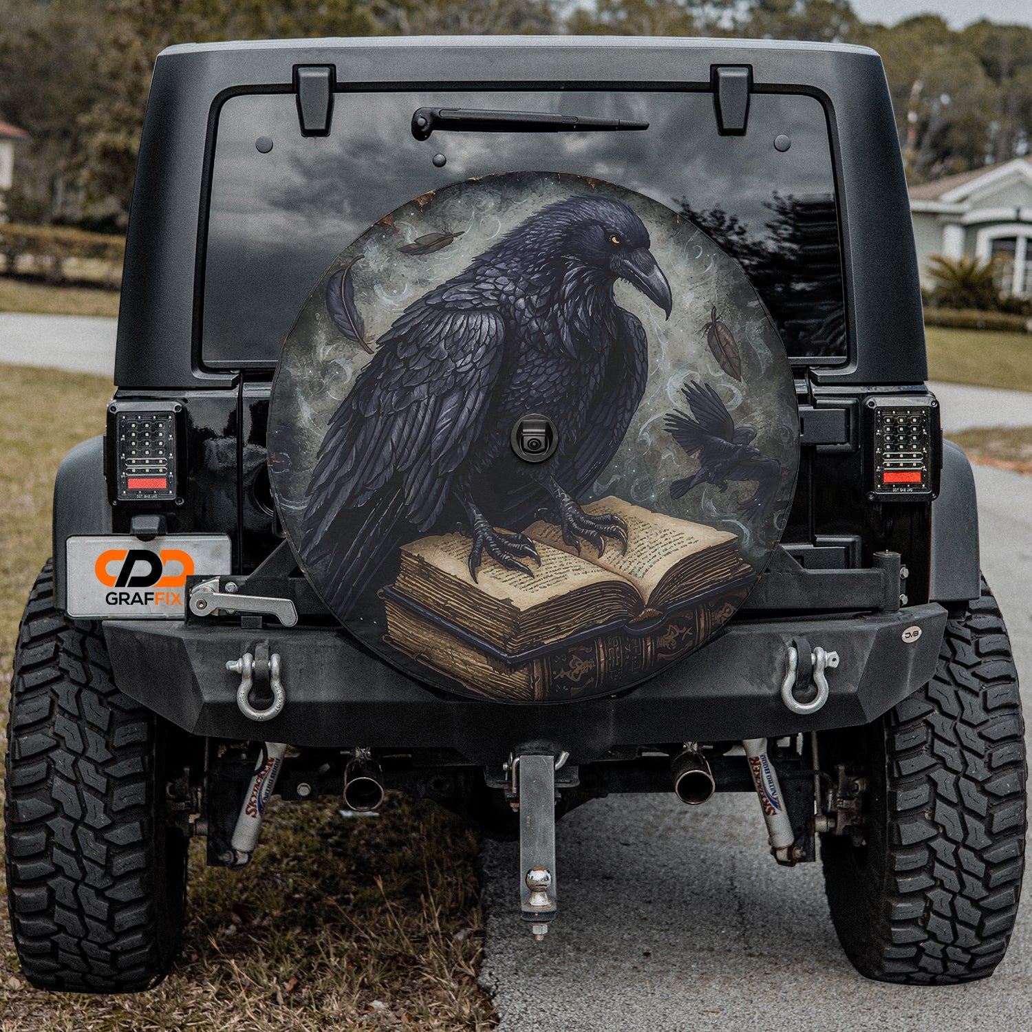 a black bird sitting on top of a book on the back of a jeep