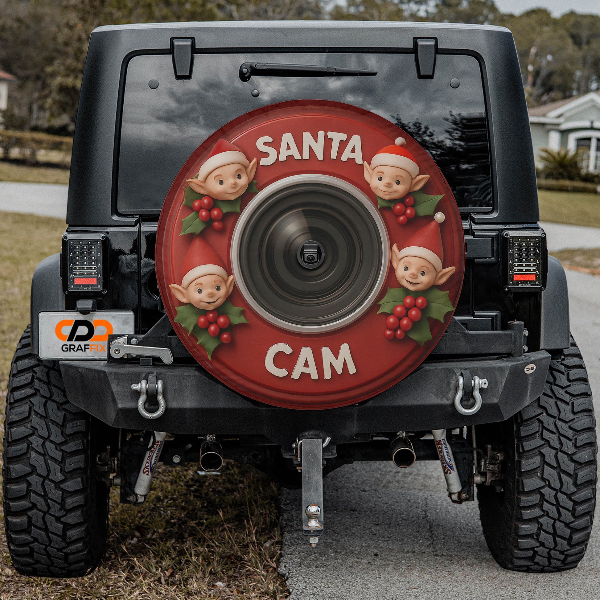 a black Jeep Wrangler with a large Santa Claus-themed spare tire attached to the rear of the vehicle.