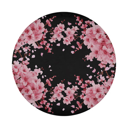 A circular design with a black background featuring a floral pattern of pink flowers.