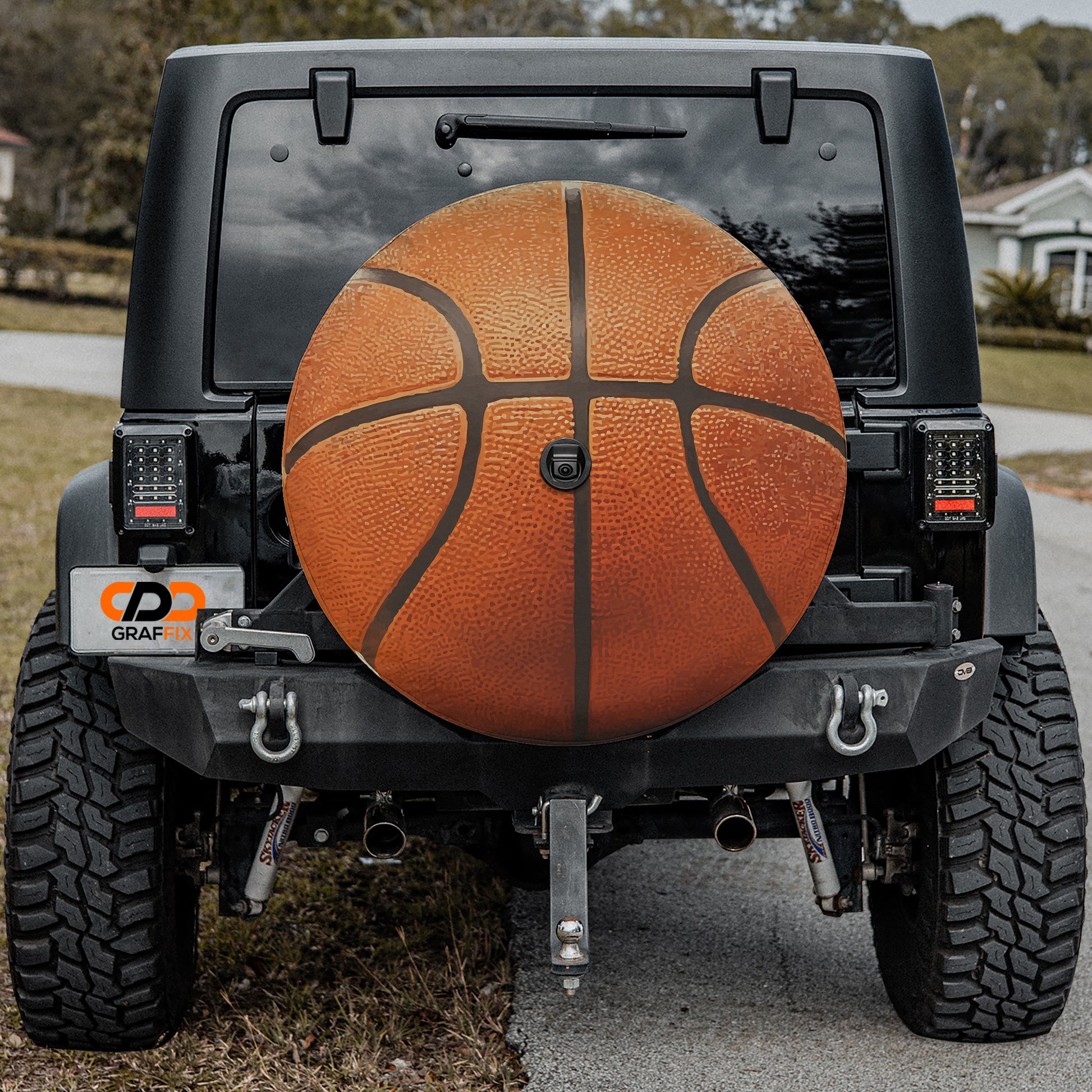 a black Jeep Wrangler with a large orange basketball mounted on the rear of the vehicle.