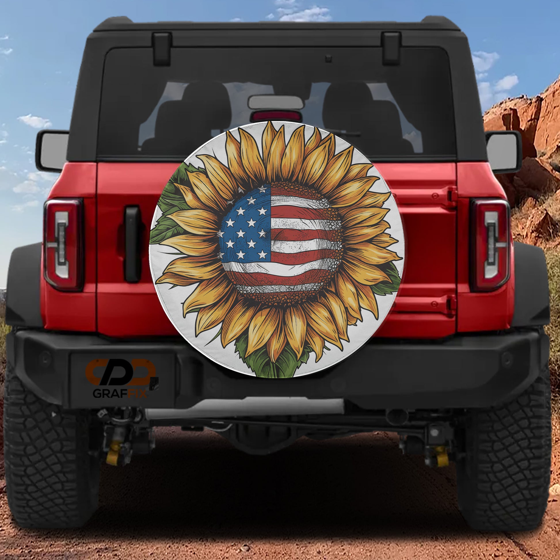 A red Jeep Wrangler with a sunflower-themed spare tire cover attached to the rear.