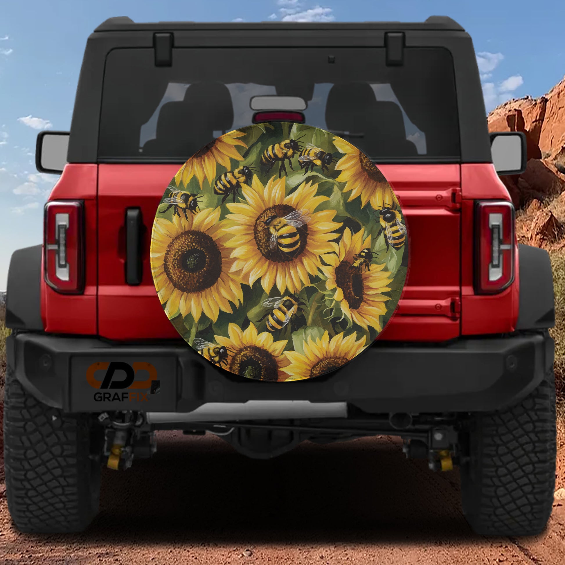a red Jeep Wrangler with a sunflower and bee-themed spare tire cover attached to the rear of the vehicle.