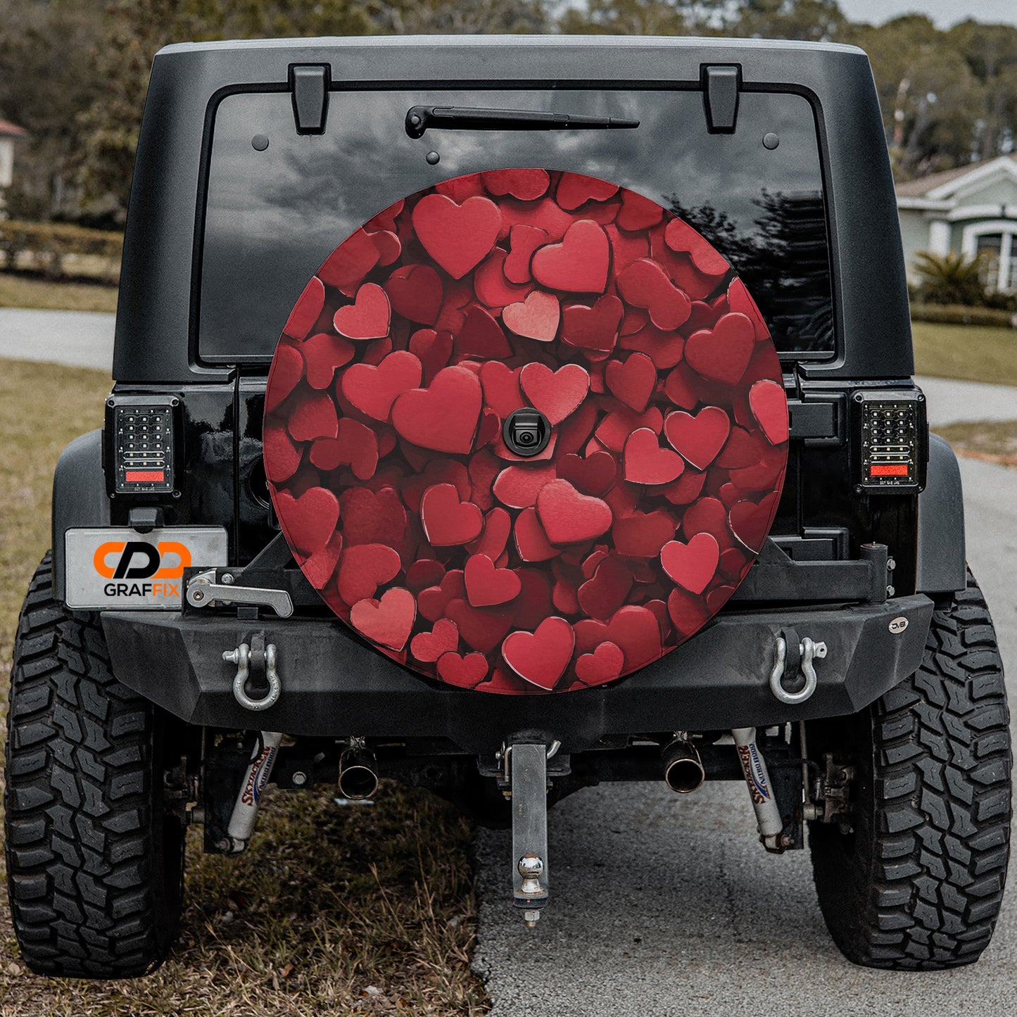 the back of a black Jeep Wrangler with a large heart-shaped spare tire attached to it.