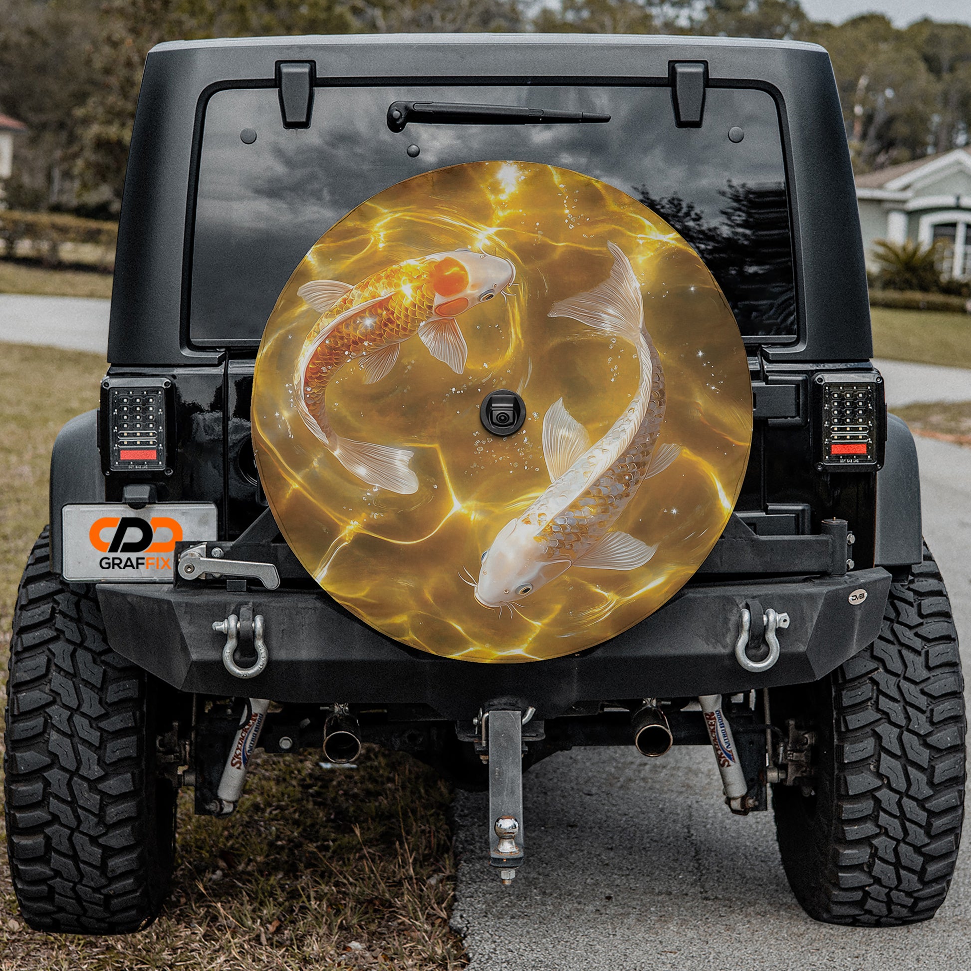 the rear of a black Jeep Wrangler with a large, round spare tire cover featuring a design of two koi fish swimming in a body of water.