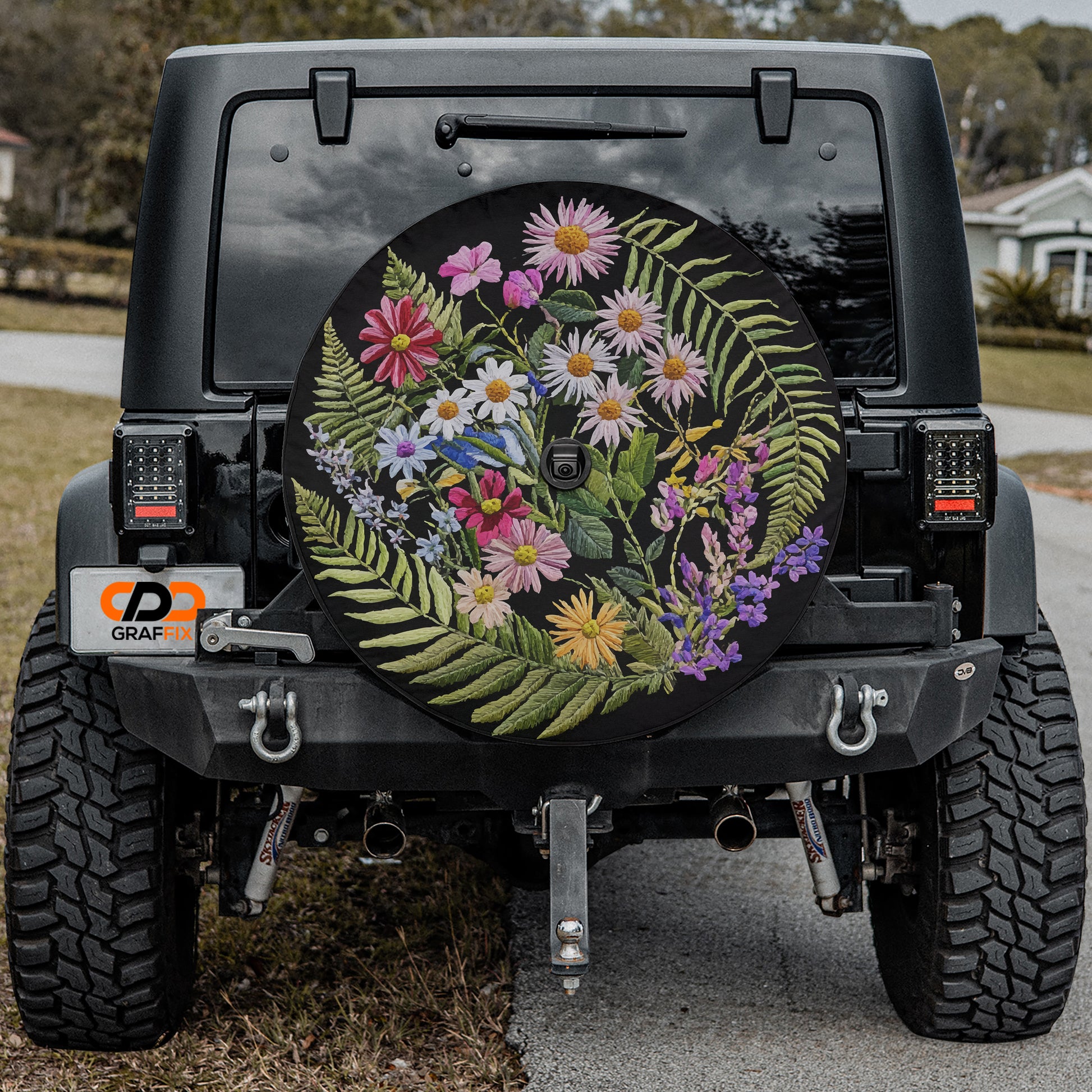a black Jeep Wrangler with a large floral decal on the rear window.