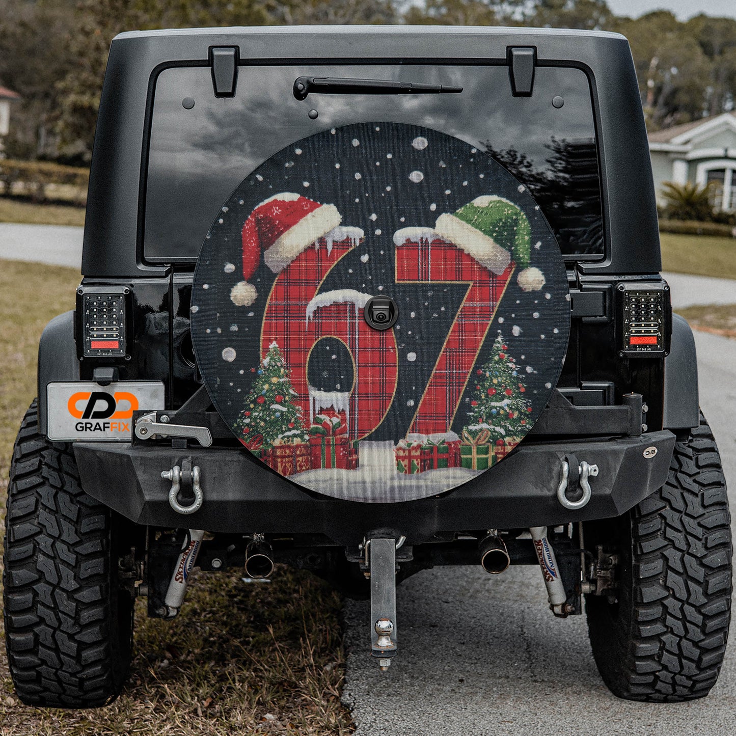 the back of a black Jeep Wrangler with a large, decorative wheel cover featuring the number "67" and Christmas-themed graphics.