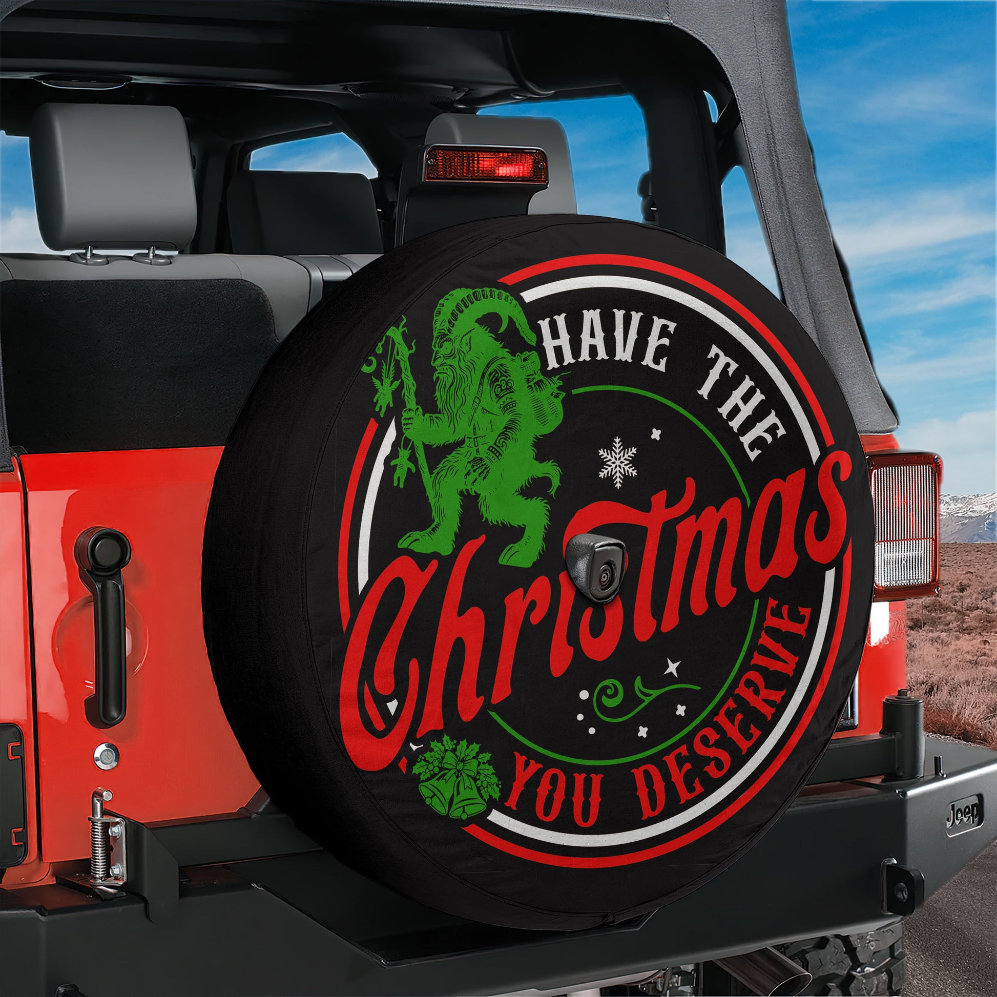 A Christmas-themed spare tire cover for a Jeep, featuring a green gnome and the text "Have the Christmas you deserve".