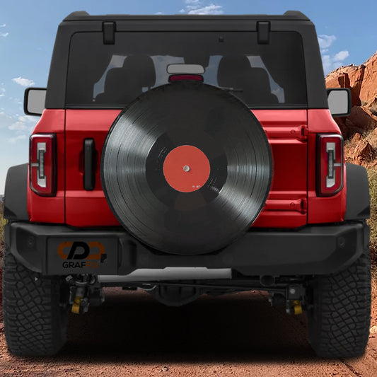 a red Jeep Wrangler with a large black record album attached to the rear of the vehicle.