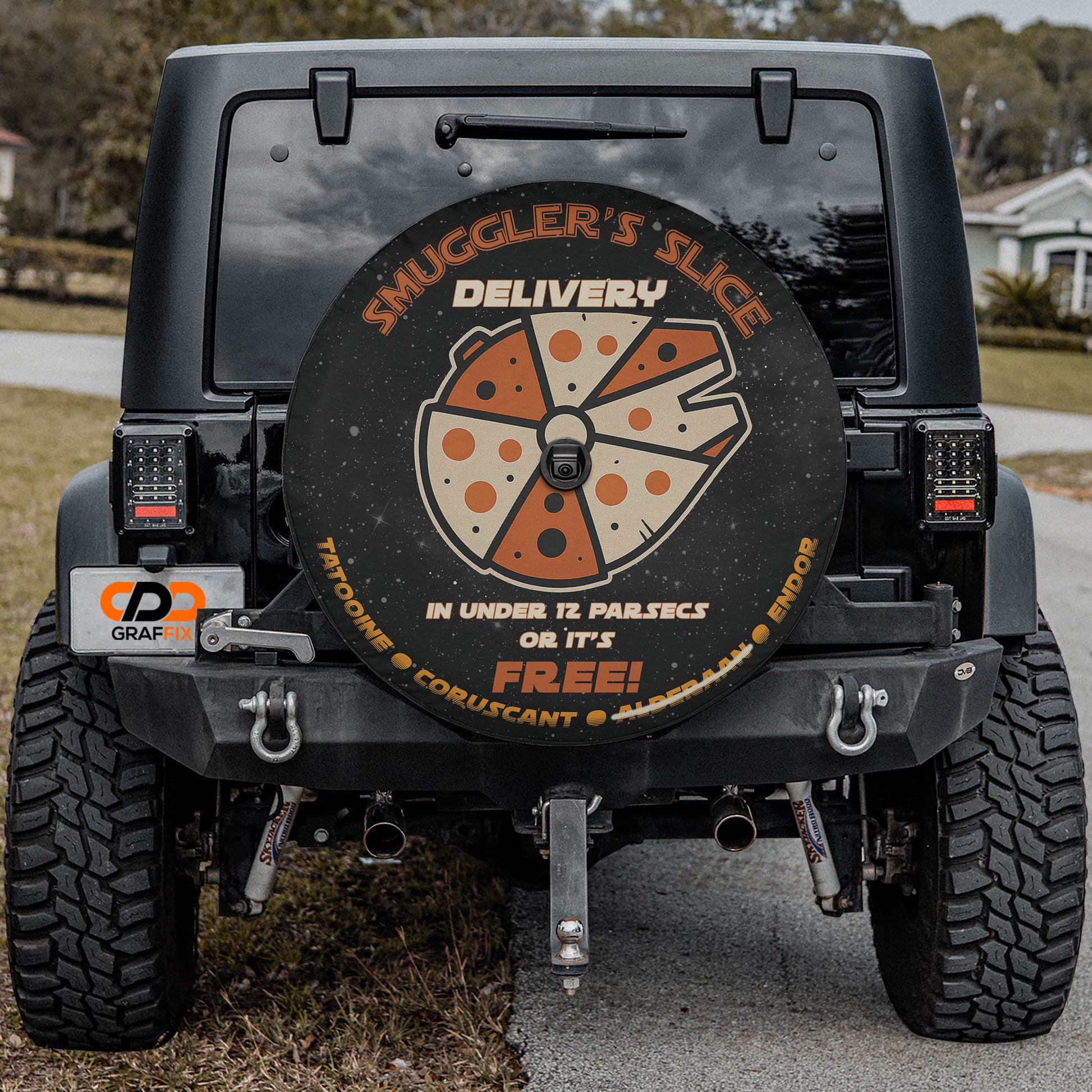 the back of a black Jeep Wrangler with a large, round, pizza-themed spare tire mounted on the vehicle.