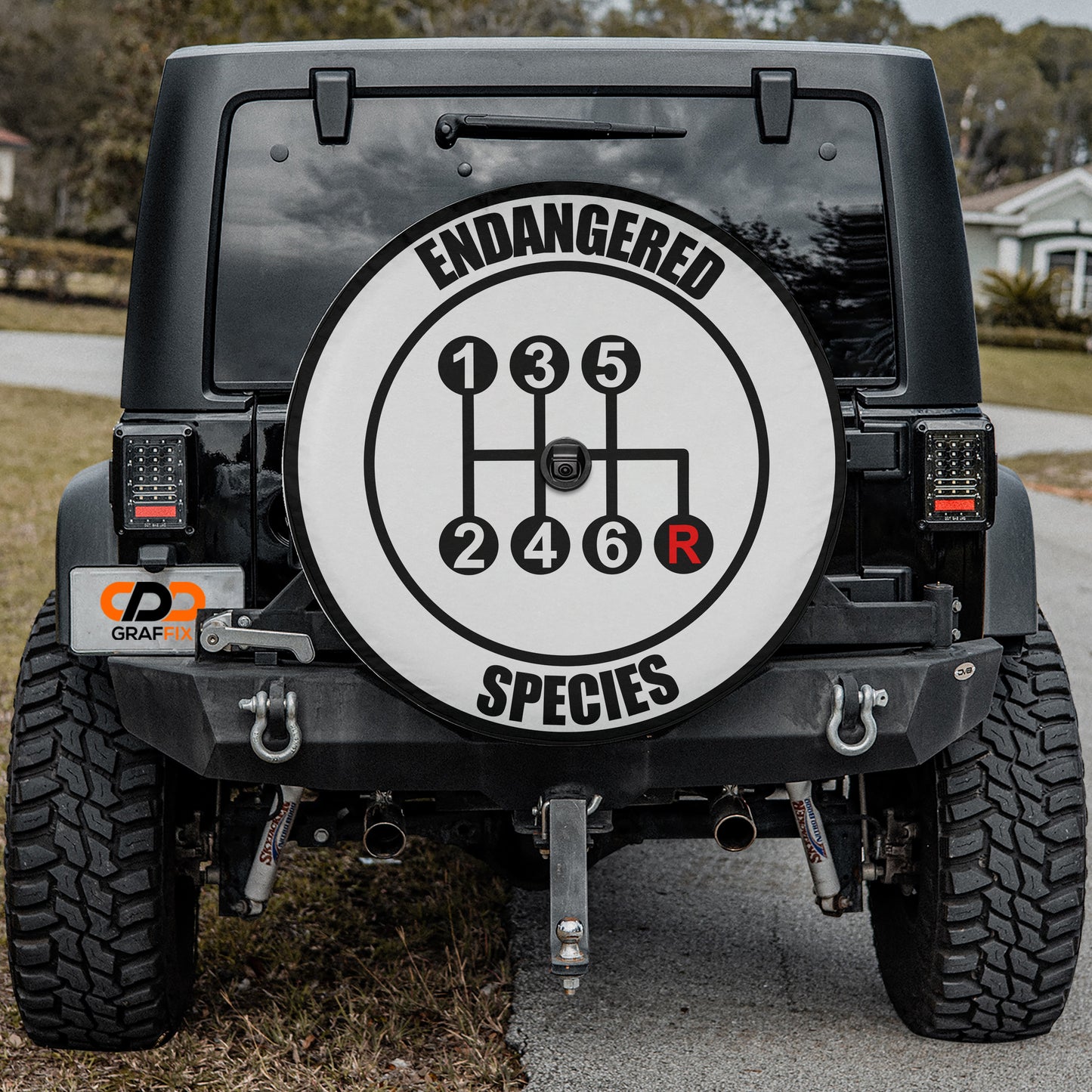 the back of a black Jeep Wrangler with a large round decal on the rear window that says "Endangered Species".