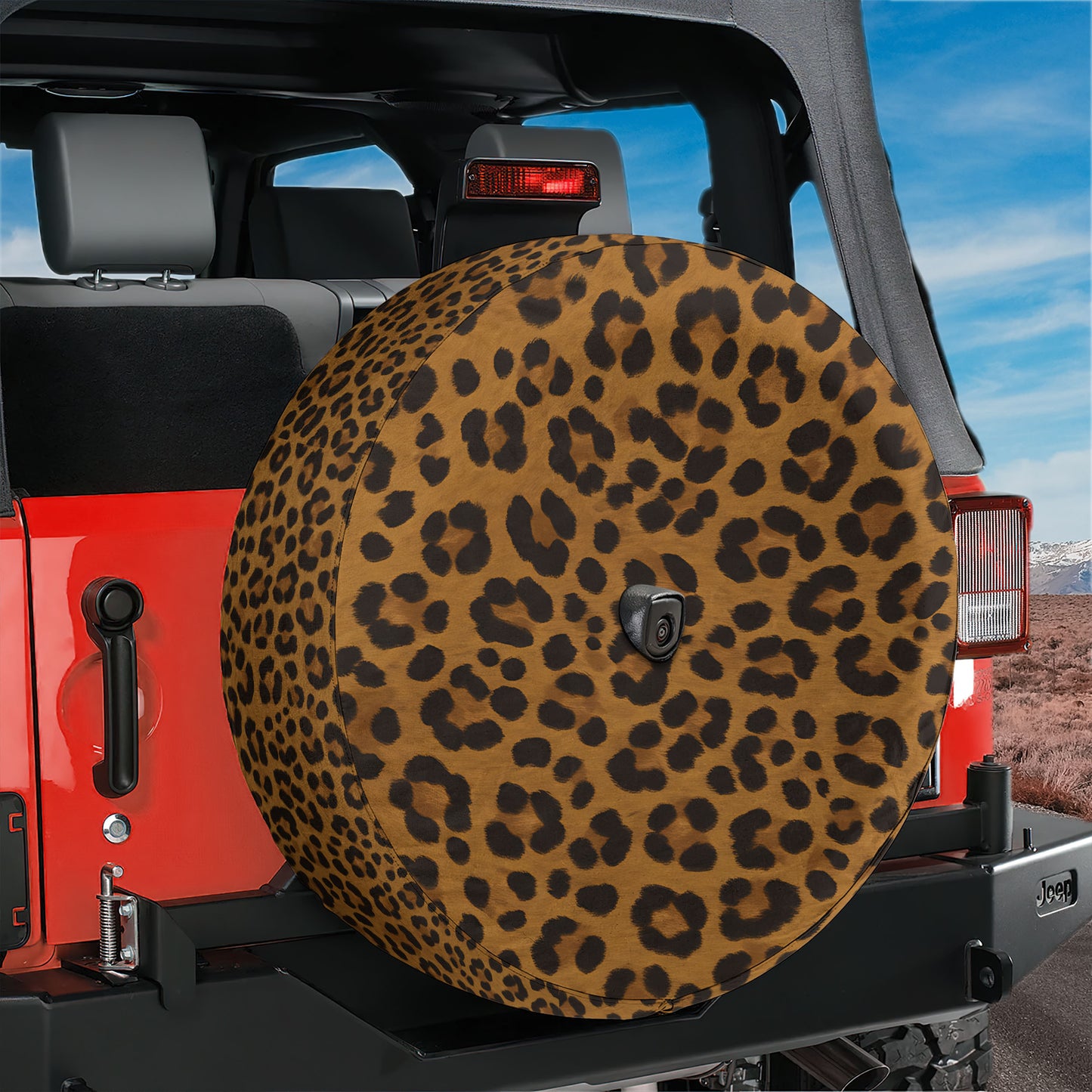 A red Jeep with a leopard print spare tire attached to the rear of the vehicle.
