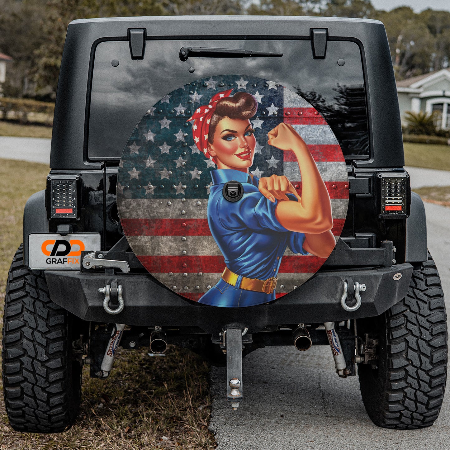 a Jeep Wrangler with a large American flag decal on the rear window, depicting a woman with a determined expression.