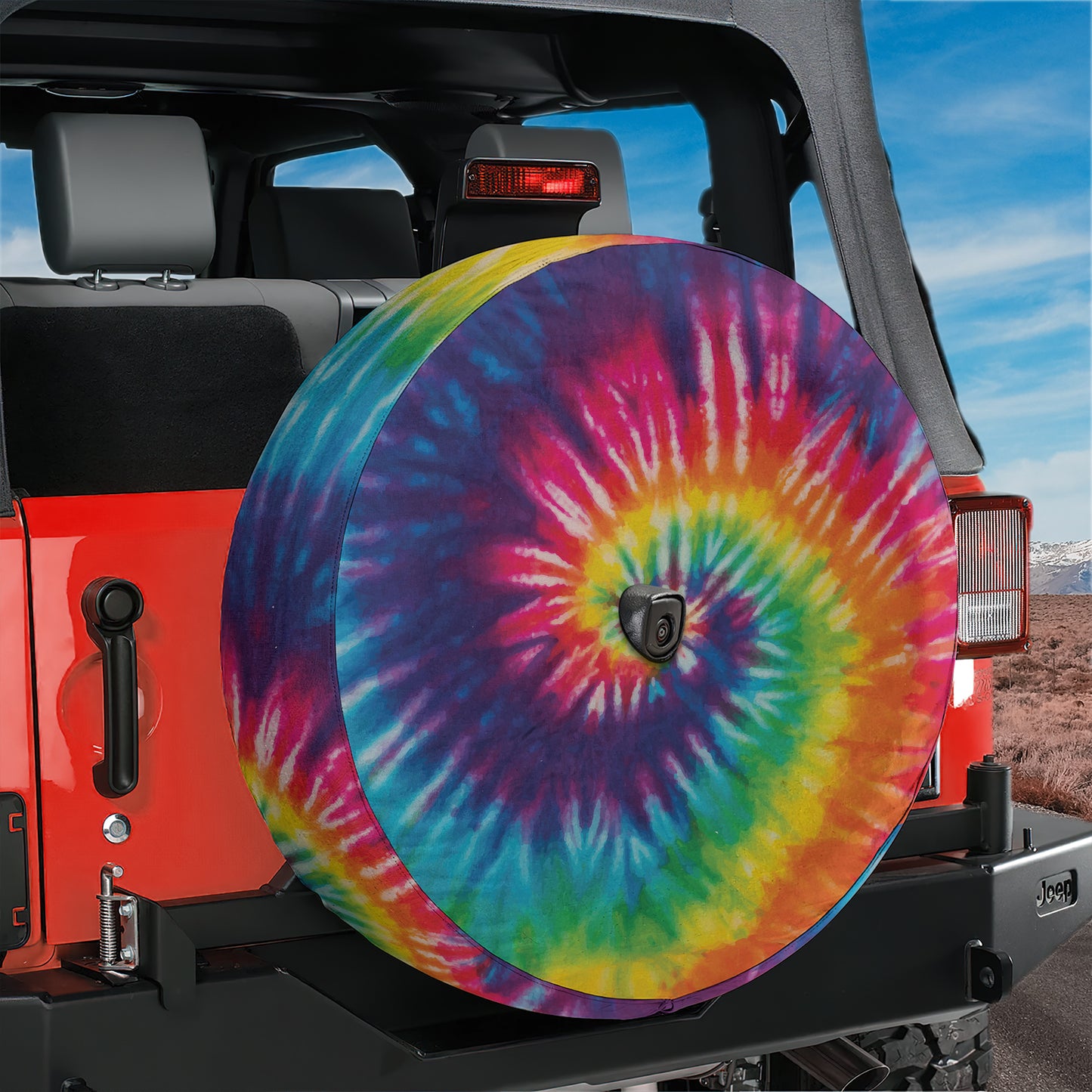 a colorful tie - dyed tire cover on a jeep