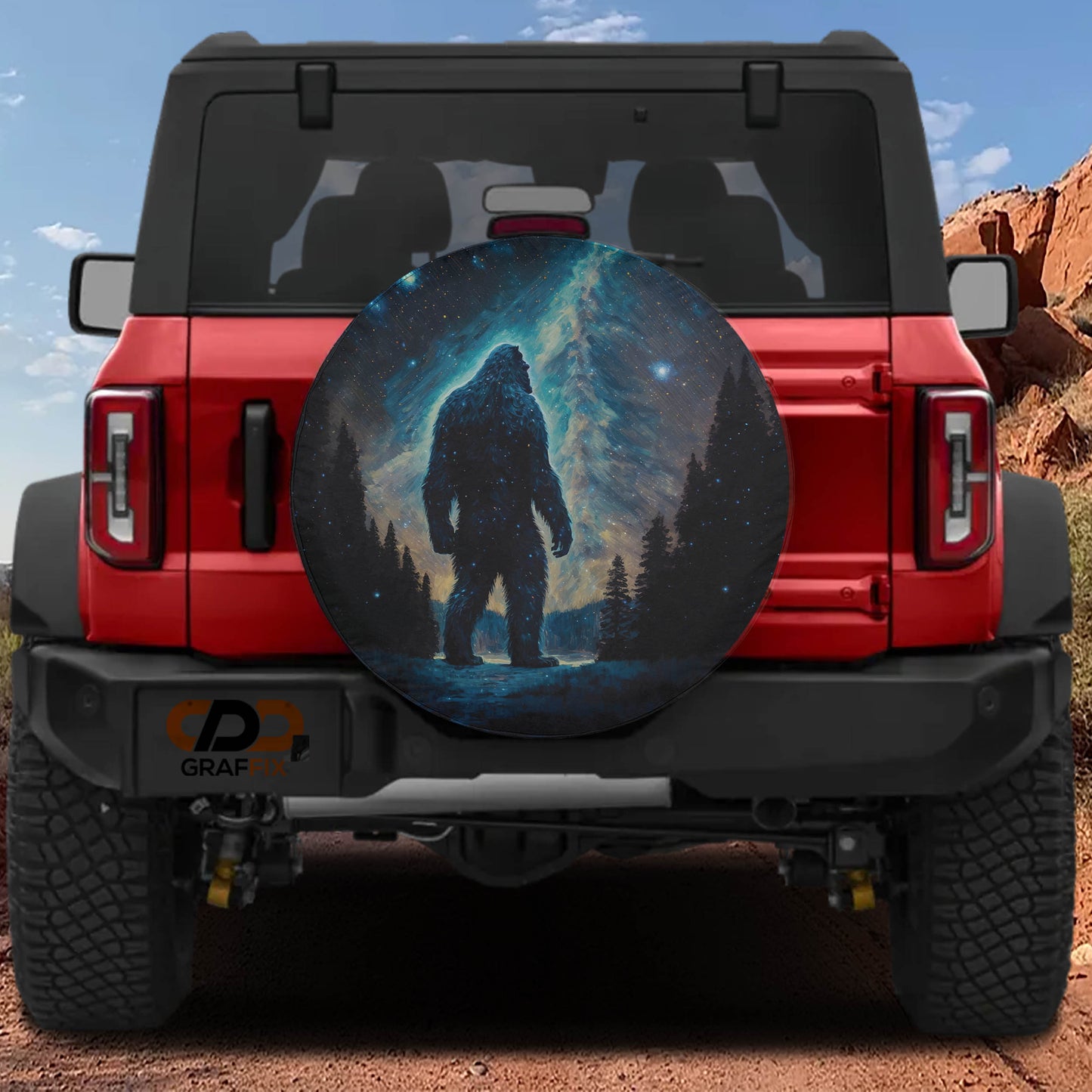 a red Jeep Wrangler with a large, circular spare tire cover depicting a giant Sasquatch.