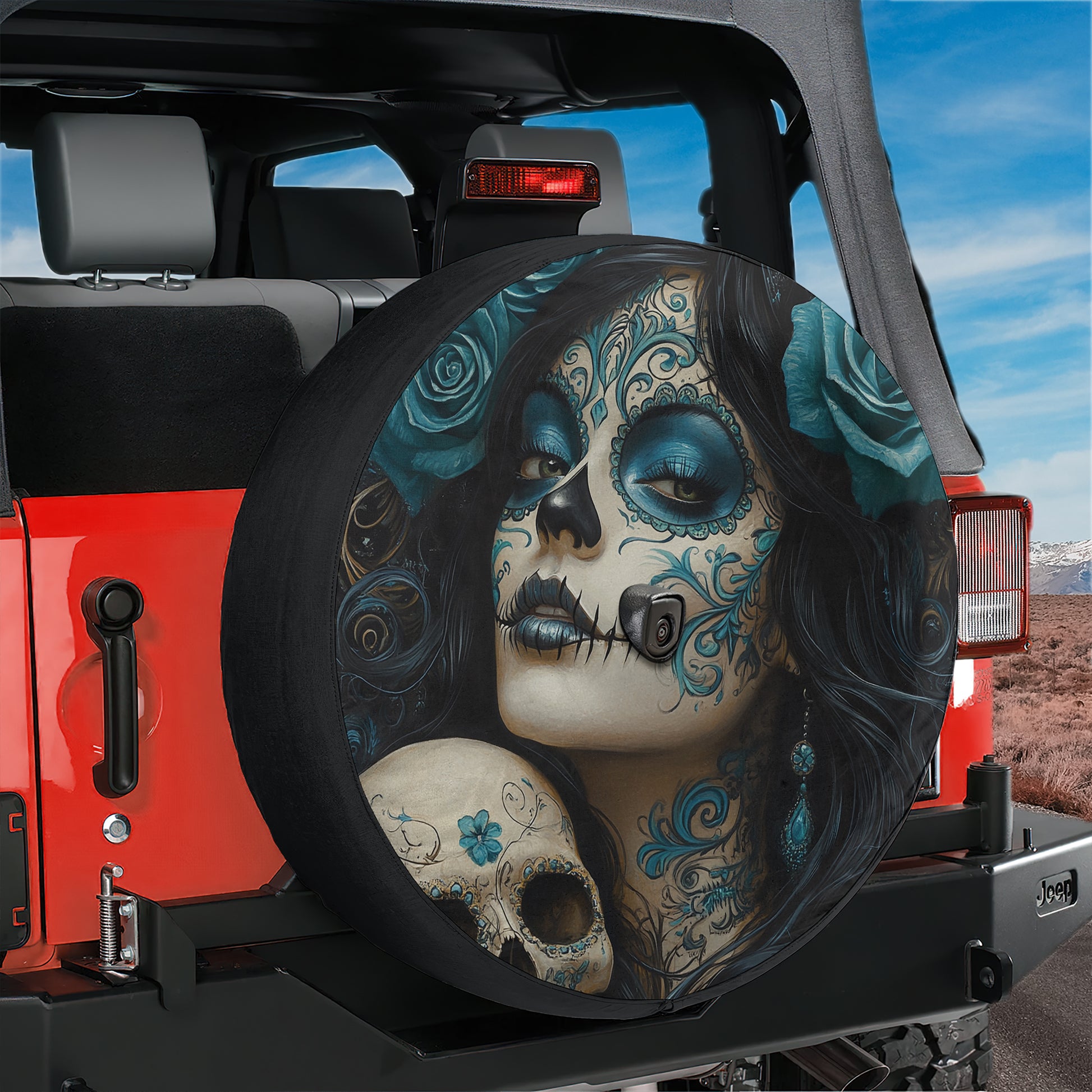 A large tire cover with a colorful design featuring a woman's face with intricate blue and black patterns, resembling Day of the Dead or skull art.