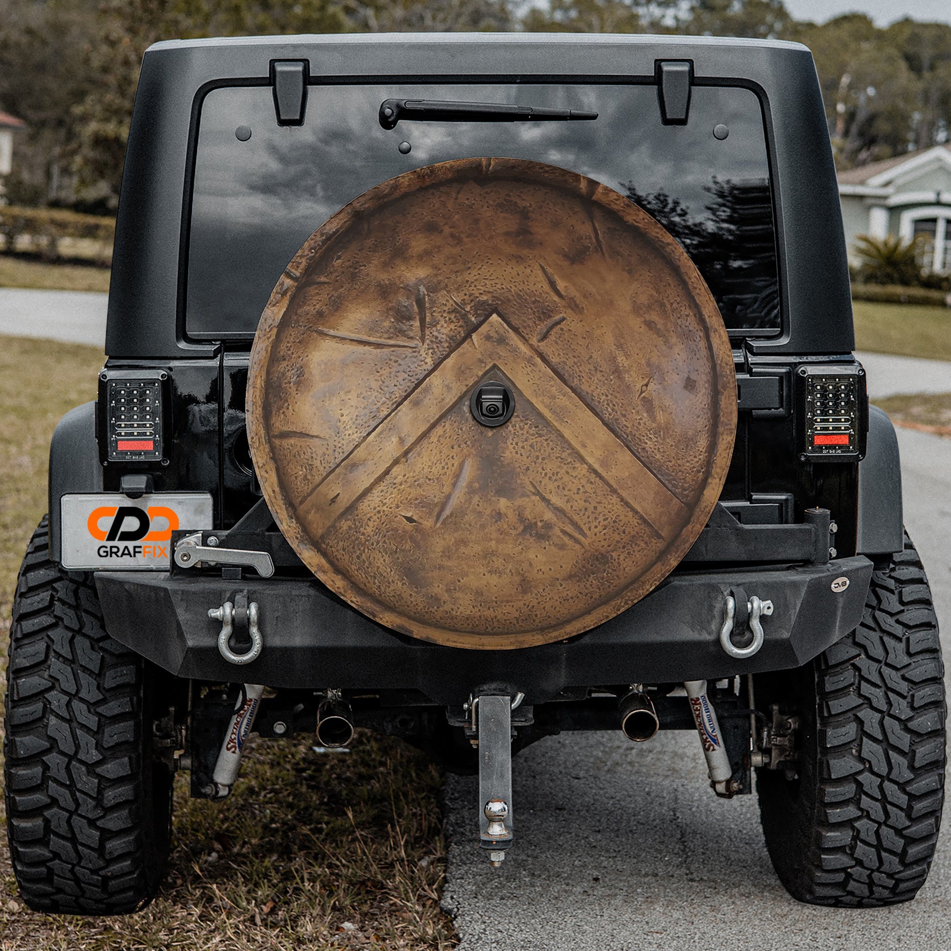 a black Jeep Wrangler with a large, round spare tire attached to the rear of the vehicle.