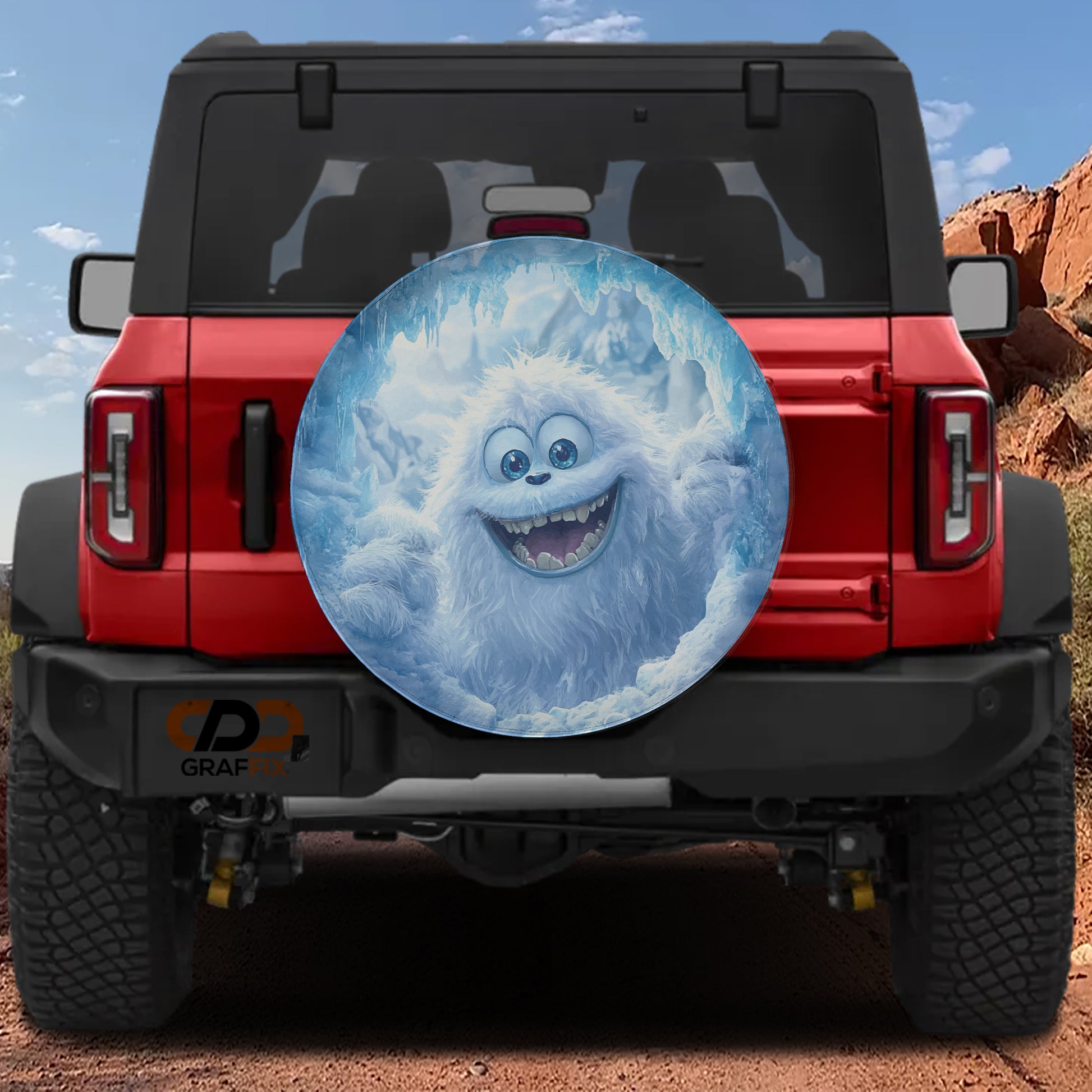 A red Jeep Wrangler with a large, cartoonish snow monster decal on the rear window.