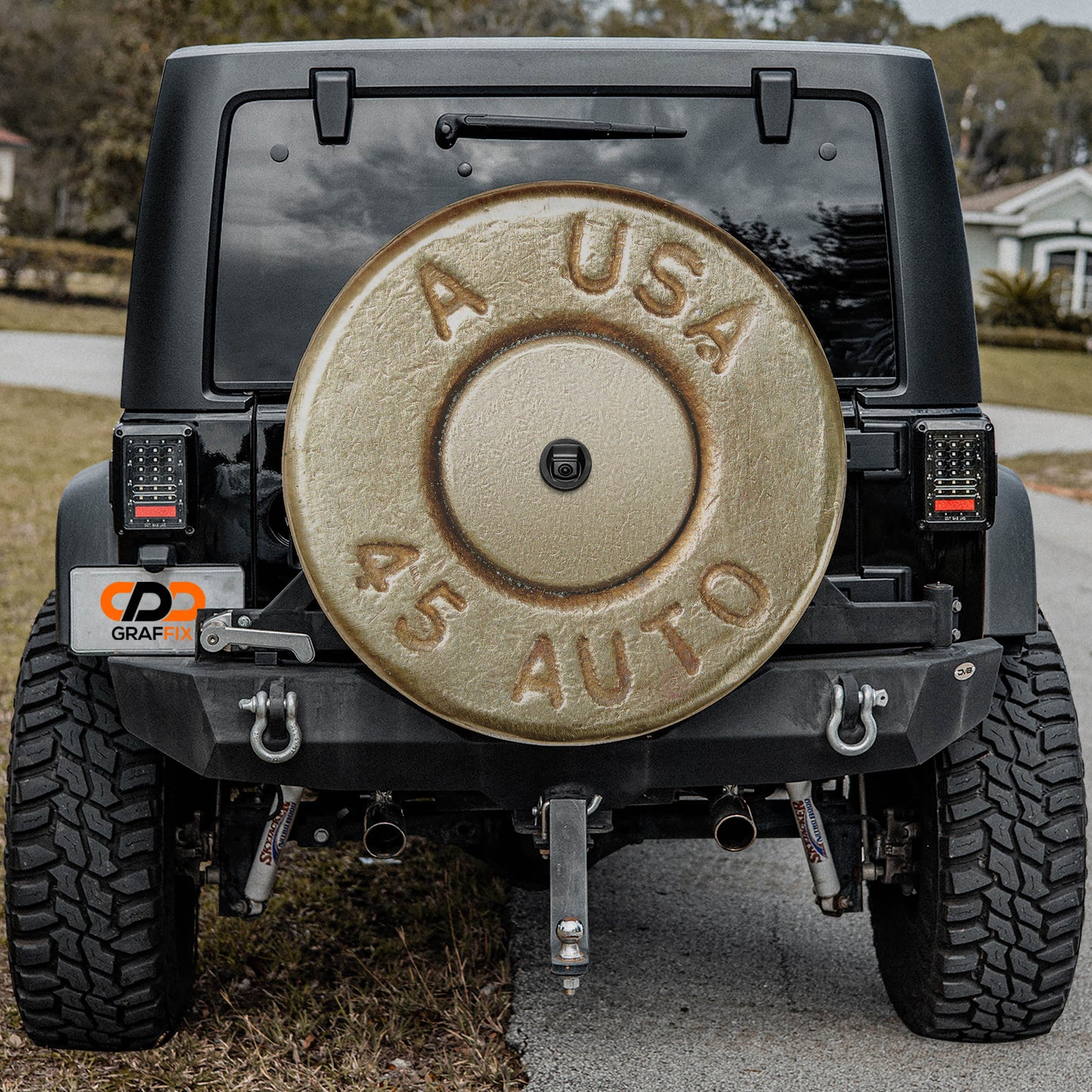 a black Jeep Wrangler with a large silver bullet-shaped spare tire attached to the rear of the vehicle.
