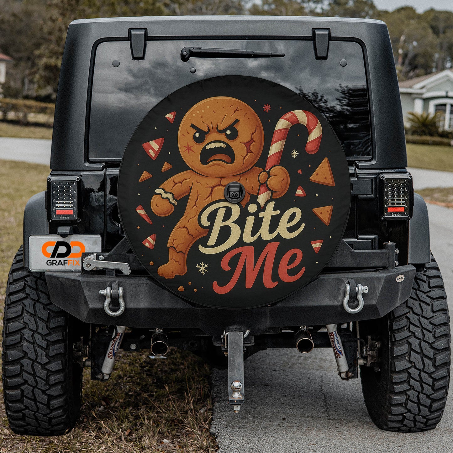 a black Jeep Wrangler with a large, round decal on the rear window that depicts a gingerbread man with a bite taken out of it.