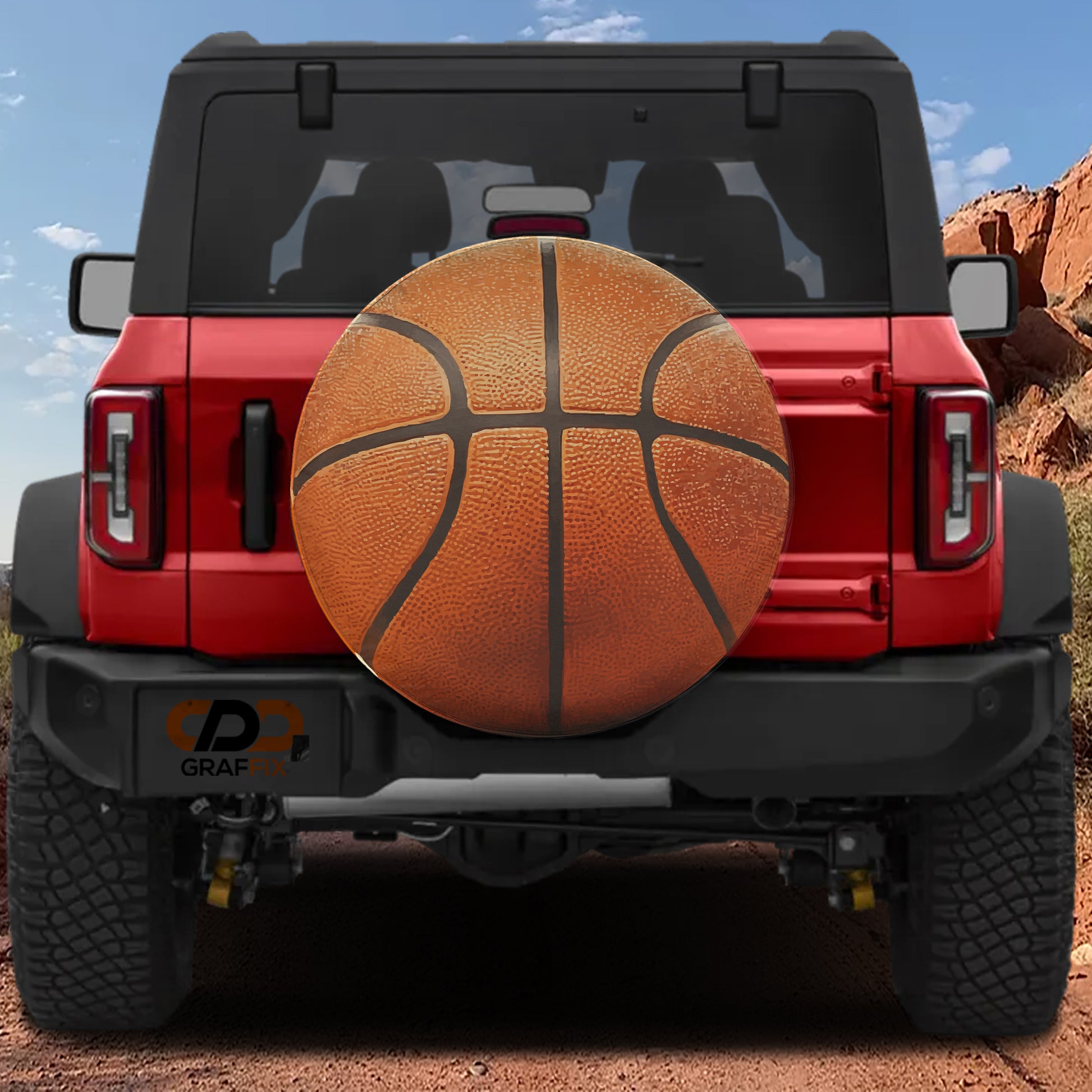 a red Jeep Wrangler with a basketball-themed spare tire attached to the rear of the vehicle.