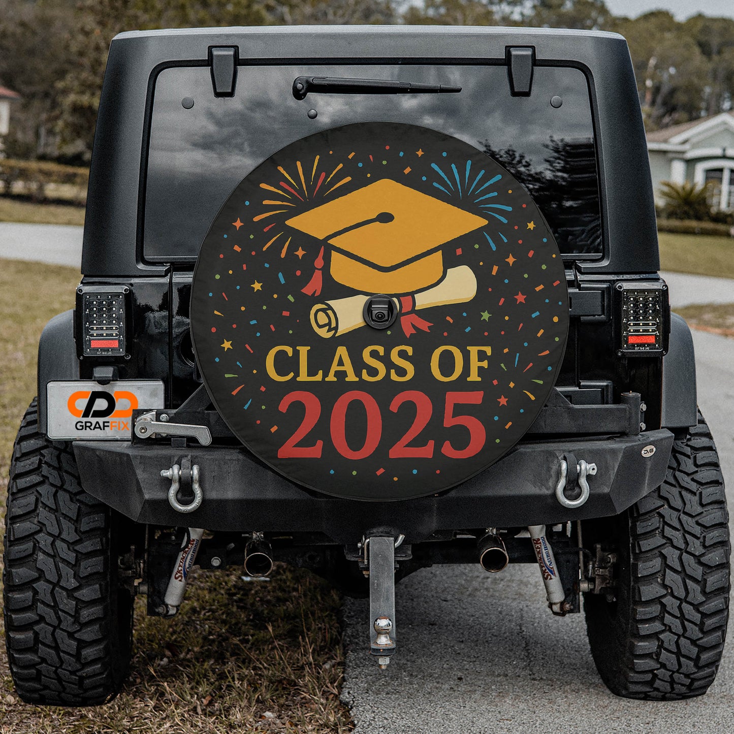 the rear of a black Jeep Wrangler with a graduation cap and fireworks design on the rear window, indicating a graduation celebration.