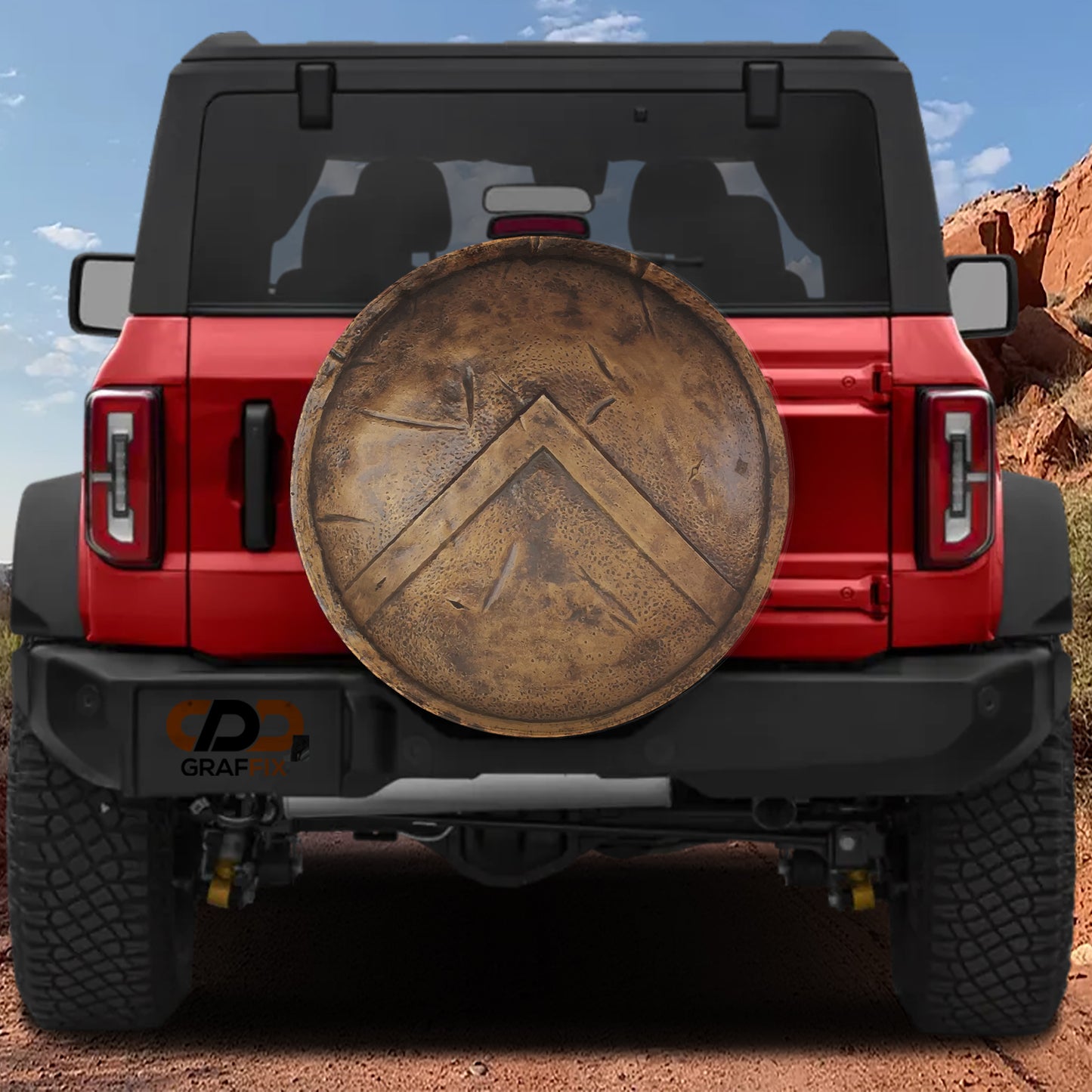 the back of a red Jeep Wrangler with a large shield-shaped object attached to the rear.
