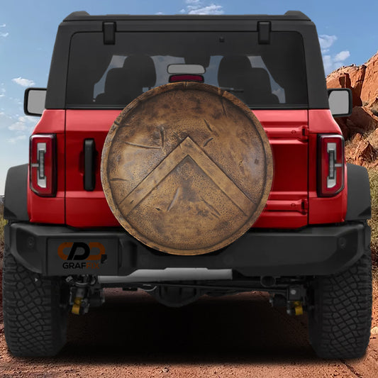 the back of a red Jeep Wrangler with a large shield-shaped object attached to the rear.