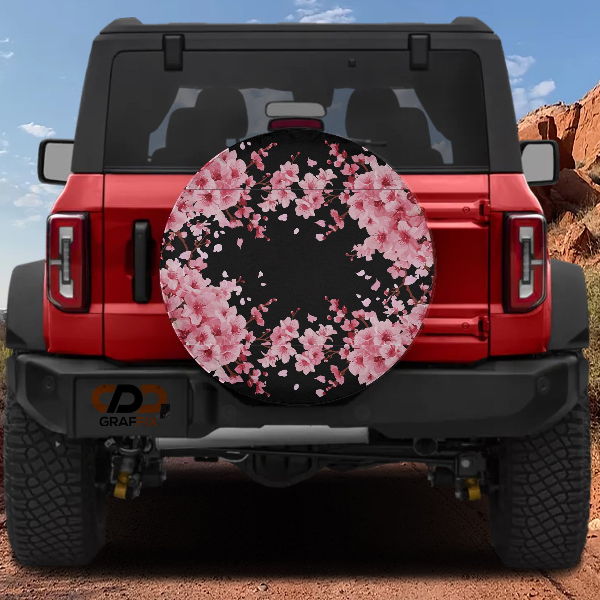 the back of a red Jeep Wrangler with a floral pattern on the spare tire cover.