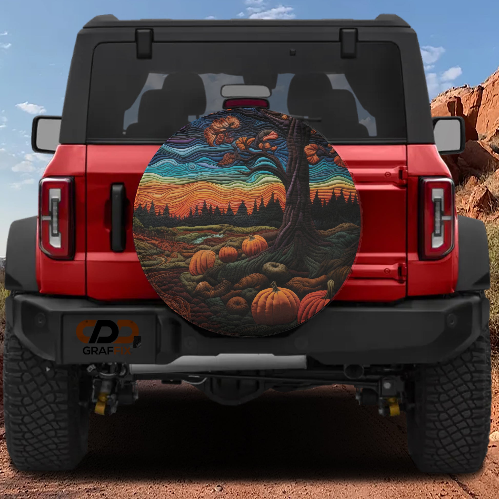 a red Jeep Wrangler with a large, colorful tire cover depicting a pumpkin patch and a tree.