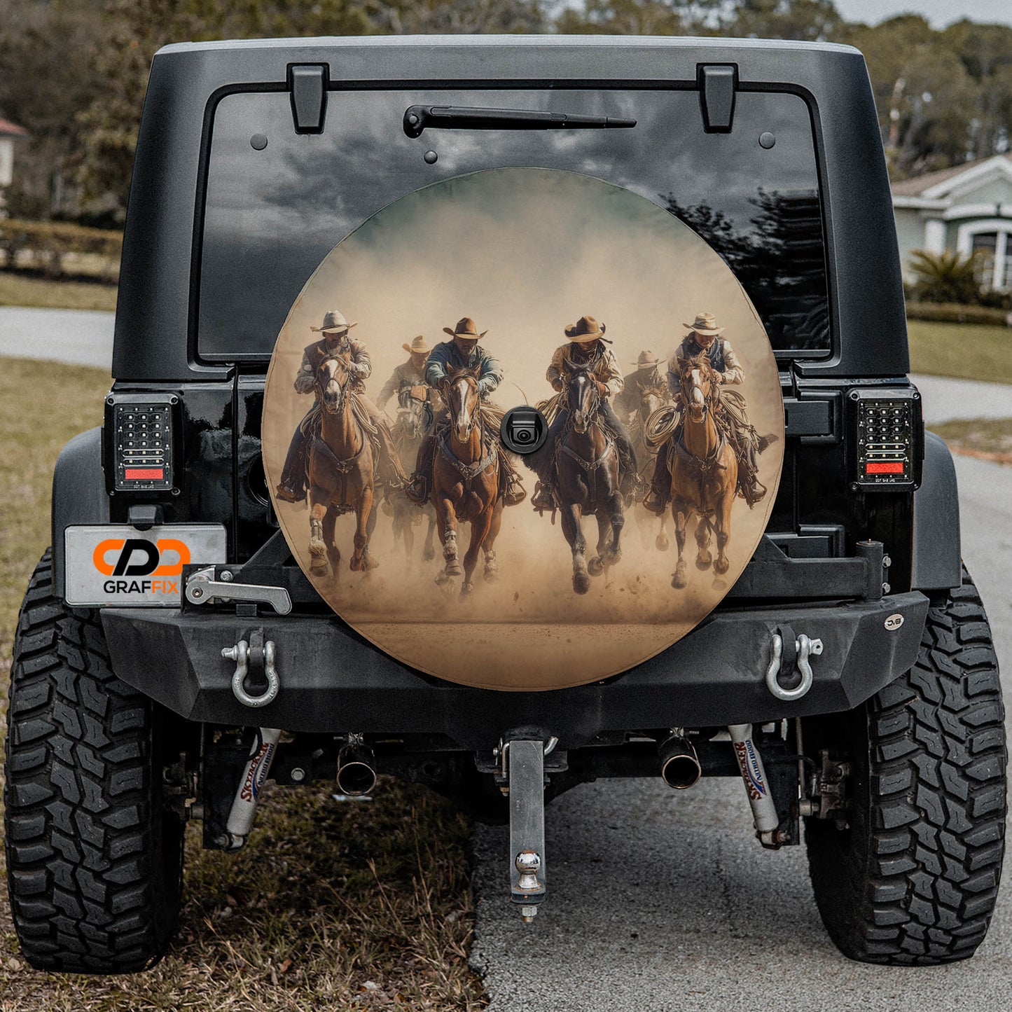 a black Jeep Wrangler with a large rear wheel cover depicting a group of people riding horses.