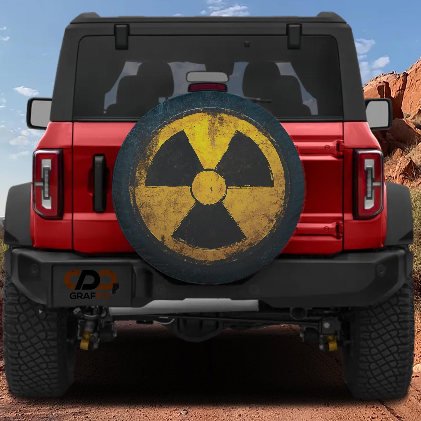 the back of a red Jeep Wrangler with a large, worn-out tire cover featuring a yellow and black radiation symbol.