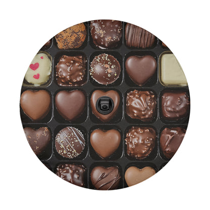 A close-up view of a box filled with various types of chocolate candies, including heart-shaped chocolates and other confections.