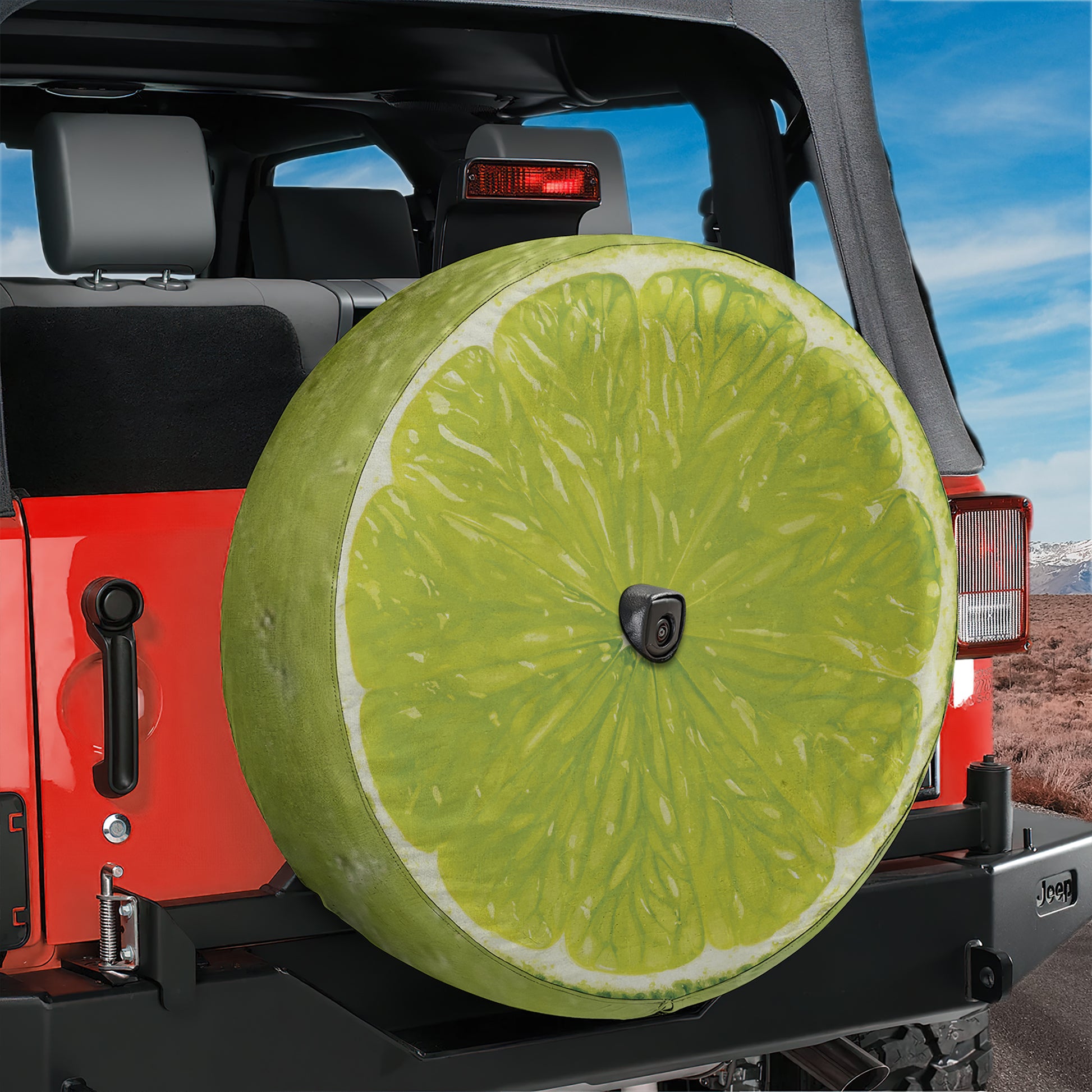 A large lime wedge is mounted on the rear of a red Jeep, serving as a unique and eye-catching spare tire.