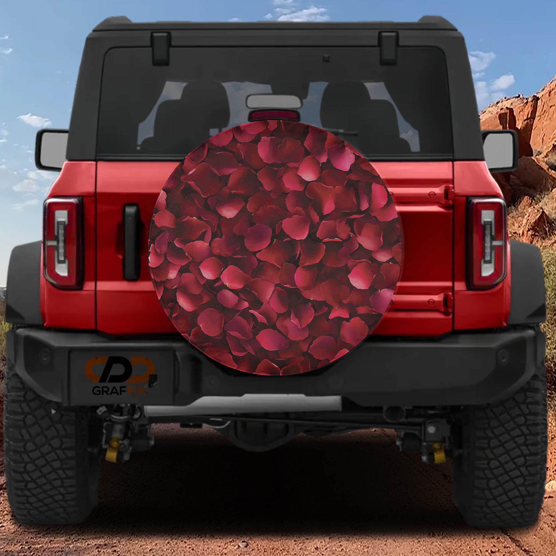A red Jeep Wrangler with a large rose-shaped spare tire attached to the rear.