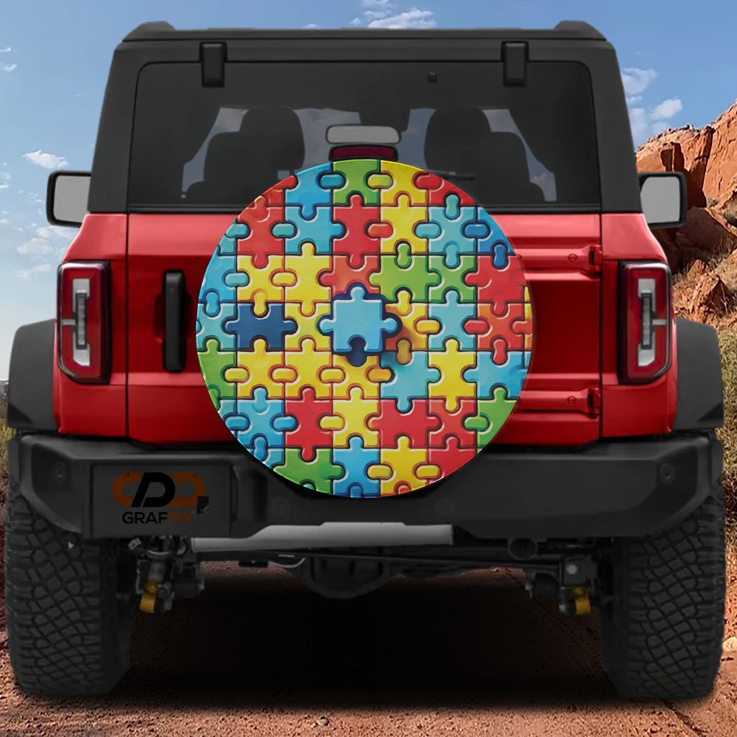 a red Jeep Wrangler with a puzzle piece-themed spare tire cover attached to the rear of the vehicle.