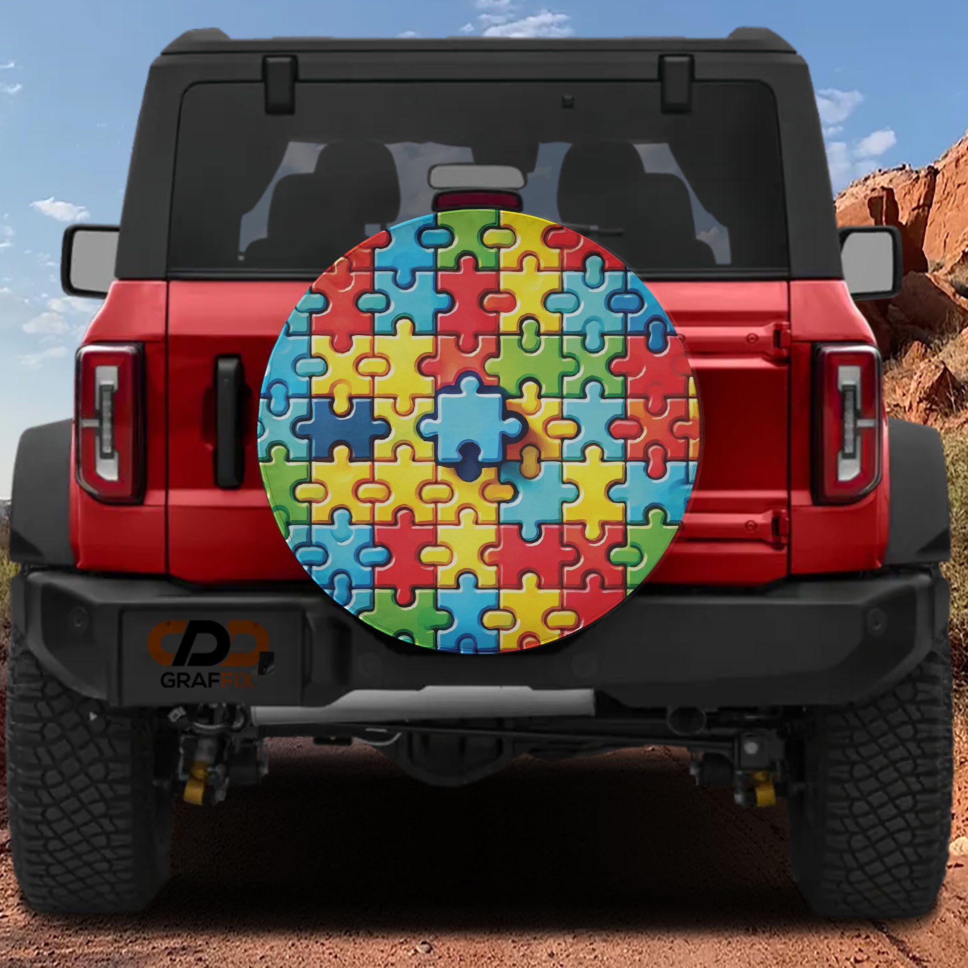 a red Jeep Wrangler with a puzzle piece-themed spare tire cover attached to the rear of the vehicle.