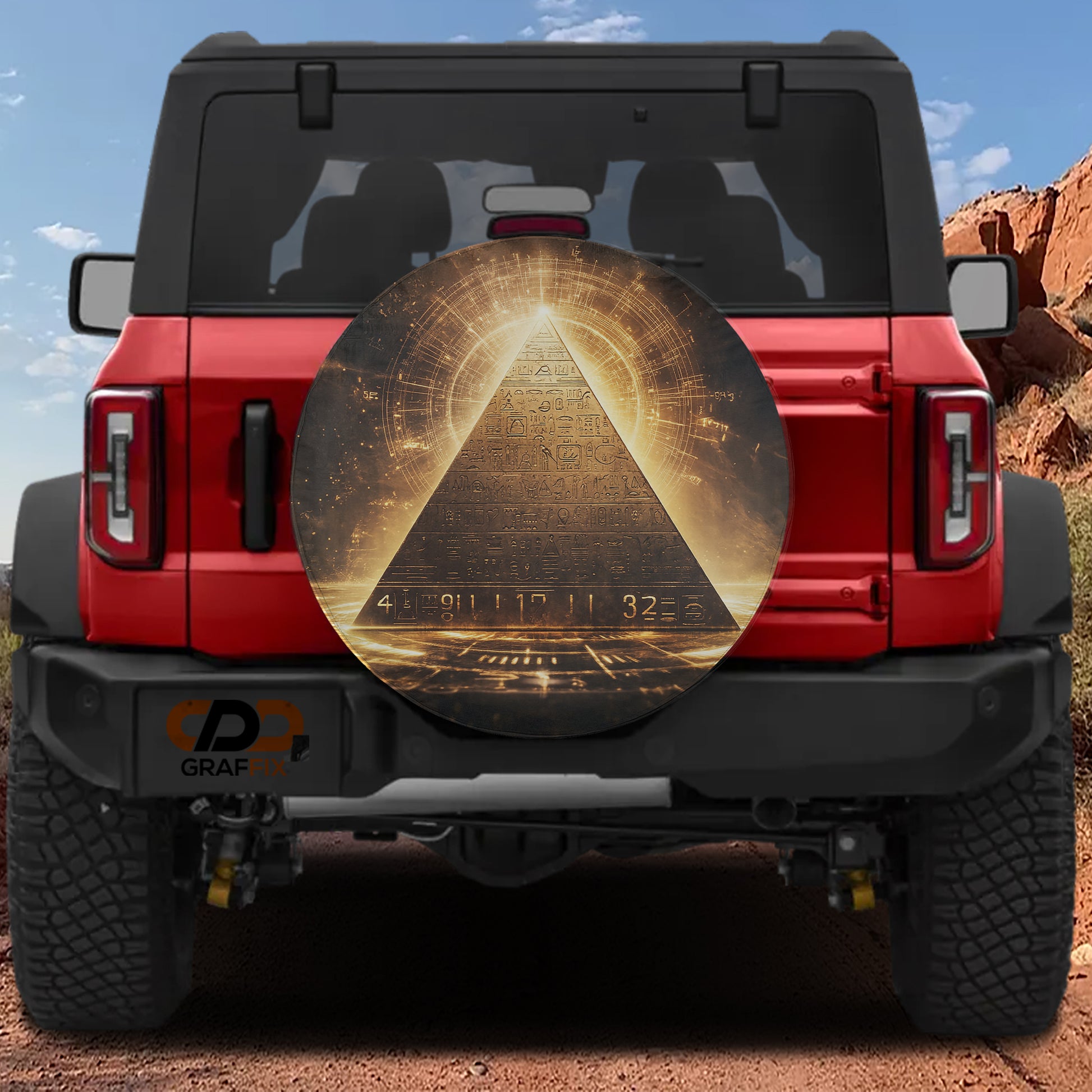 a red Jeep Wrangler with a large, circular decal on the rear window depicting a pyramid with a golden glow at the top.