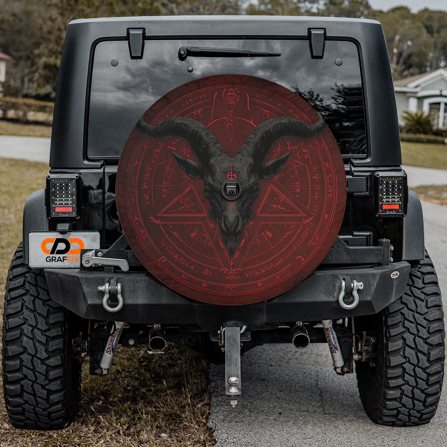 the back of a black Jeep Wrangler with a large red wheel cover featuring a skull and crossbones design.