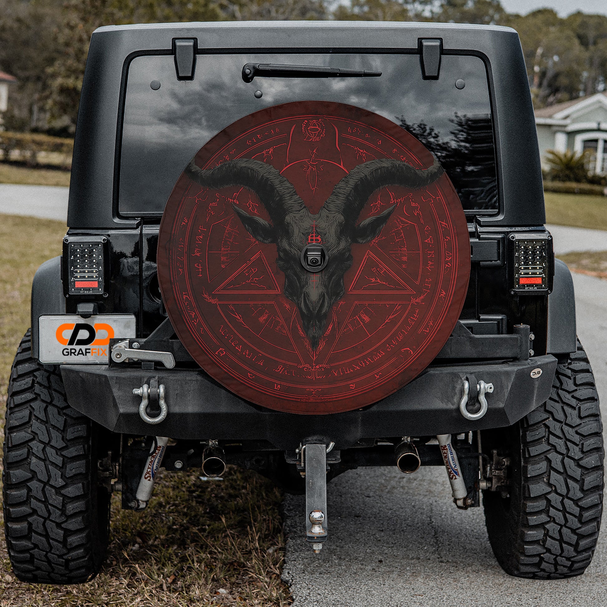 the back of a black Jeep Wrangler with a large red wheel cover featuring a skull and crossbones design.
