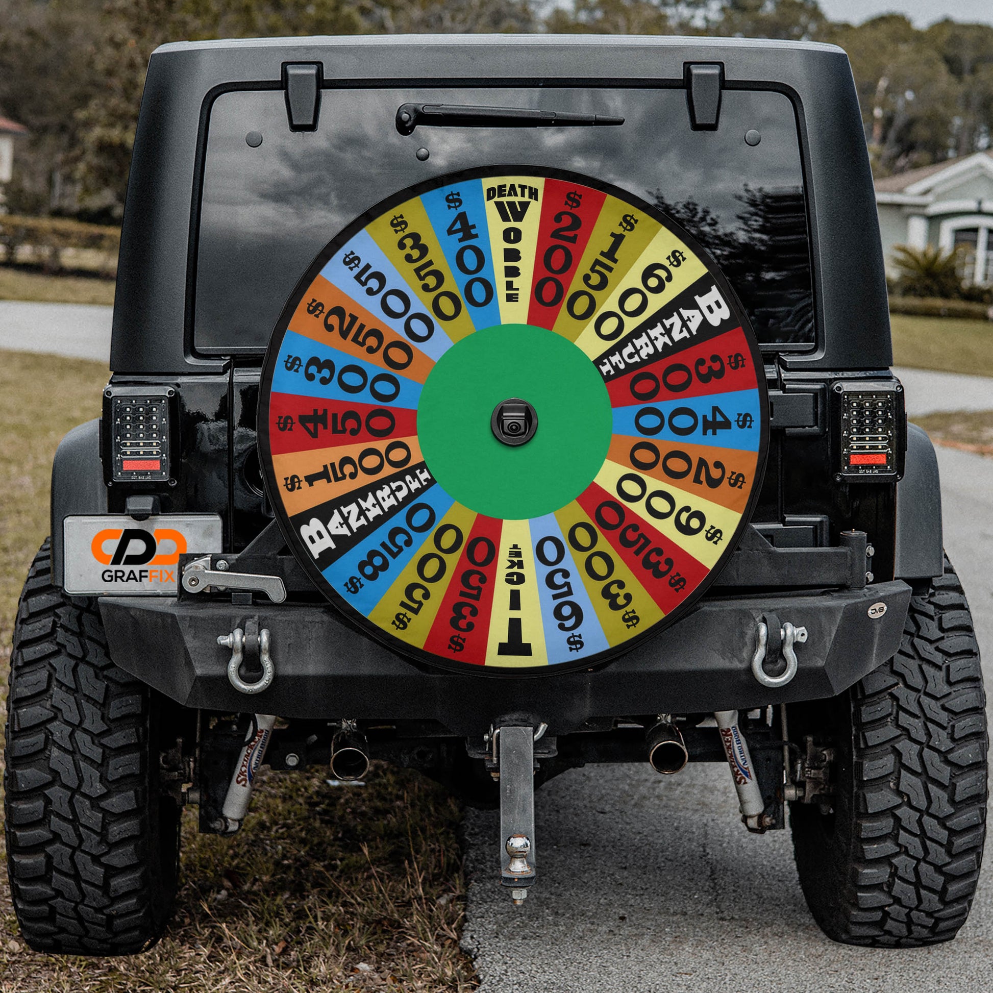 a black Jeep Wrangler with a large, colorful wheel attached to the rear of the vehicle.