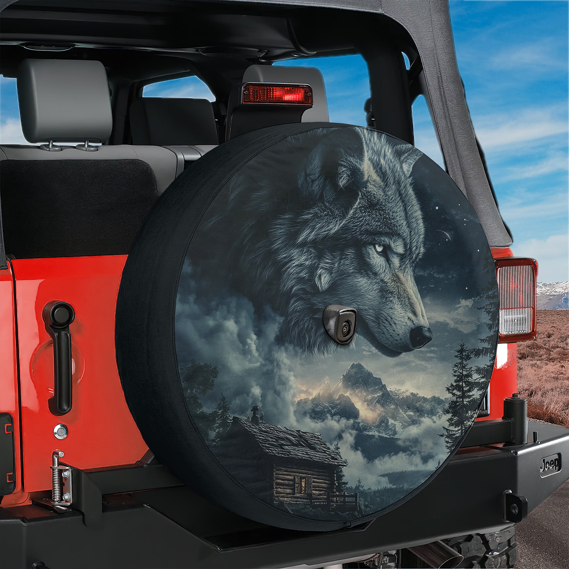 A large, round spare tire cover with a wolf's head design on it, mounted on the rear of a red Jeep.