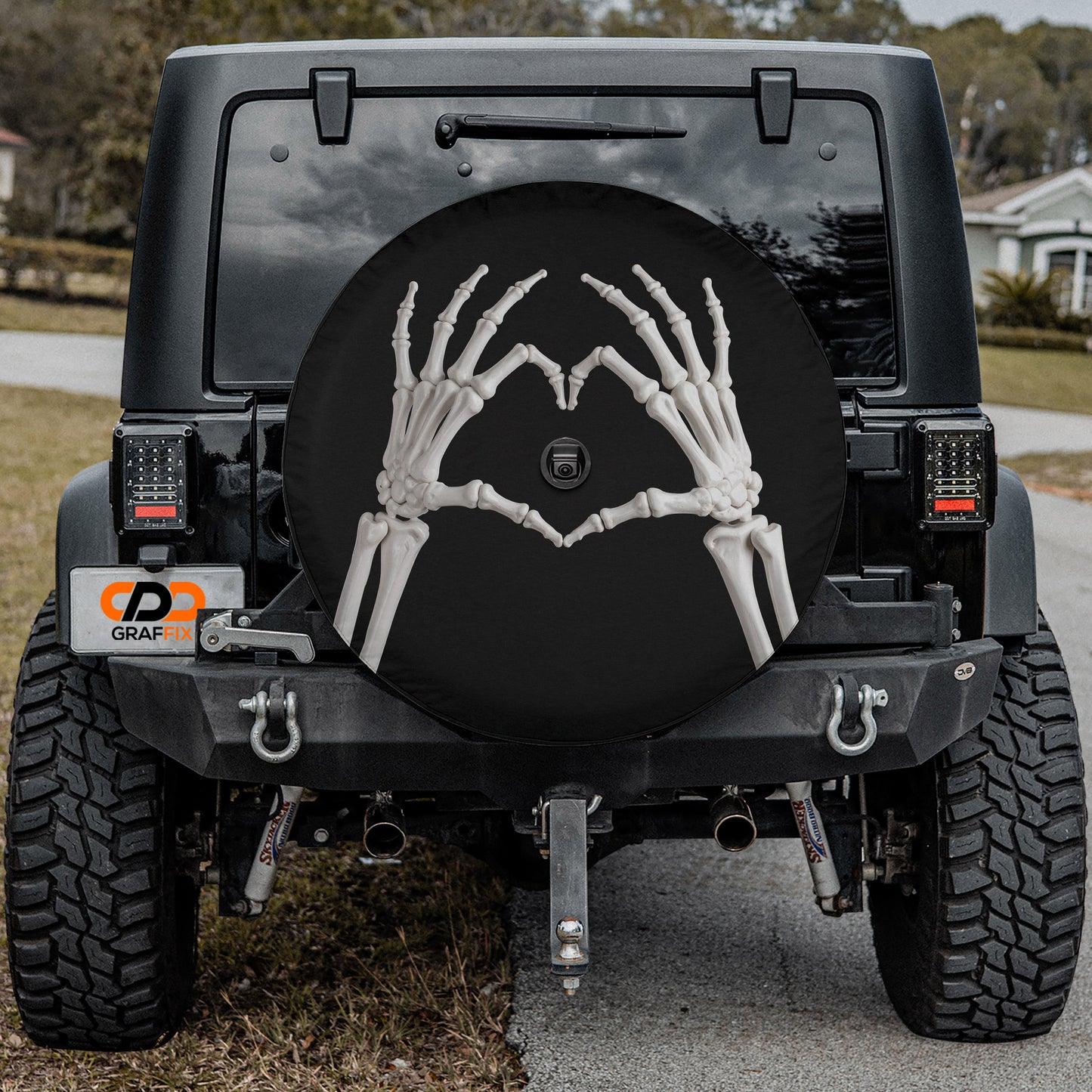 a black Jeep Wrangler with a skeleton hand decal on the rear window.