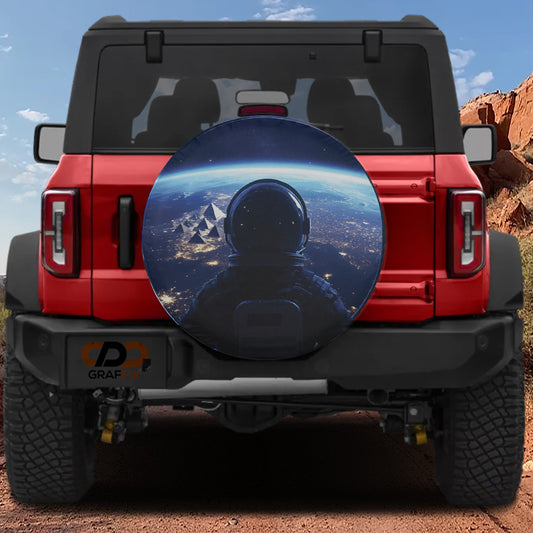a red Jeep Wrangler with a large, round spare tire cover that depicts an astronaut in a space suit, looking out at a cityscape.