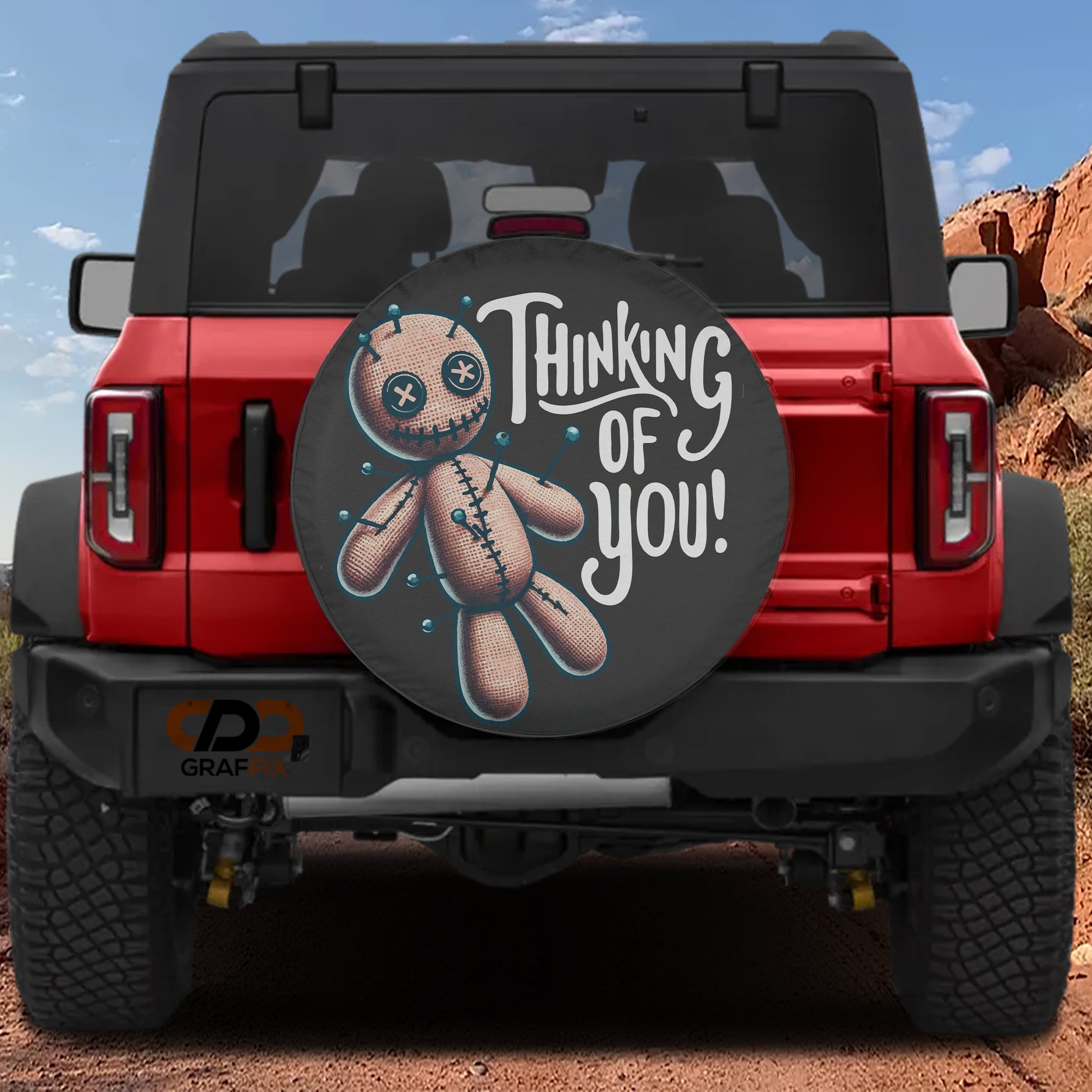 a red Jeep Wrangler with a tire cover that has a cartoon character and the text "Thinking of You!" printed on it.