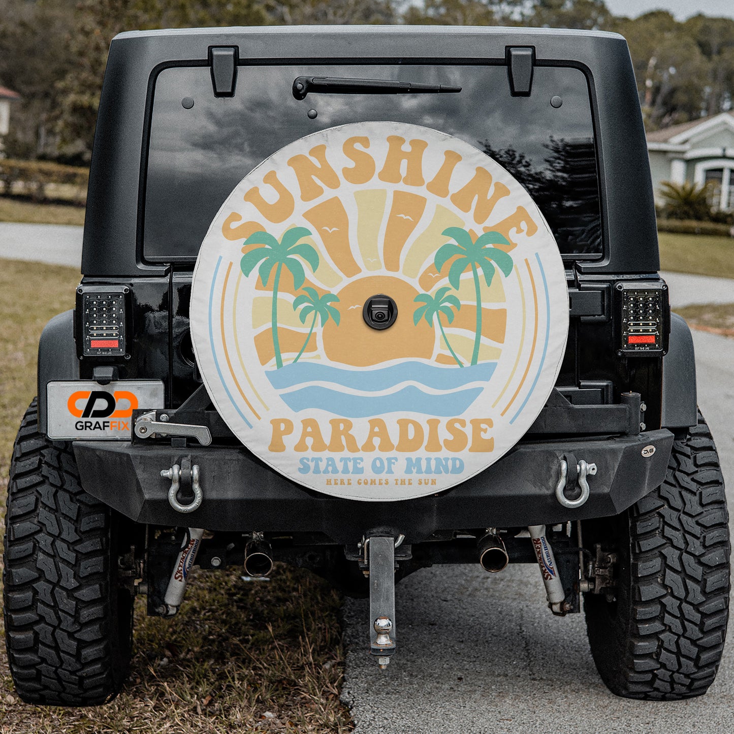 the back of a black Jeep Wrangler with a large round decal on the rear window that says "SUNSHINE PARADISE STATE OF MIND HERE COMES THE SUN".