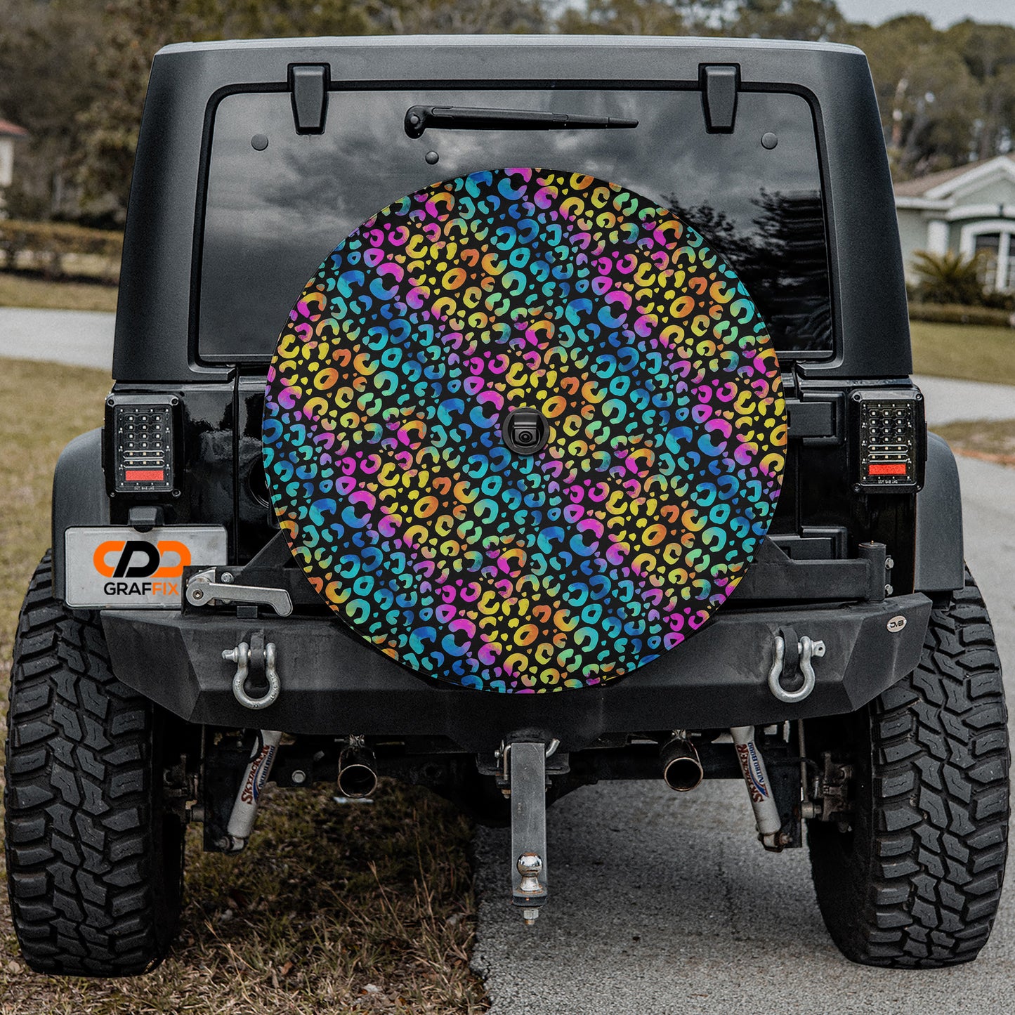 the rear of a black Jeep Wrangler with a colorful, leopard print wheel cover attached to the vehicle.