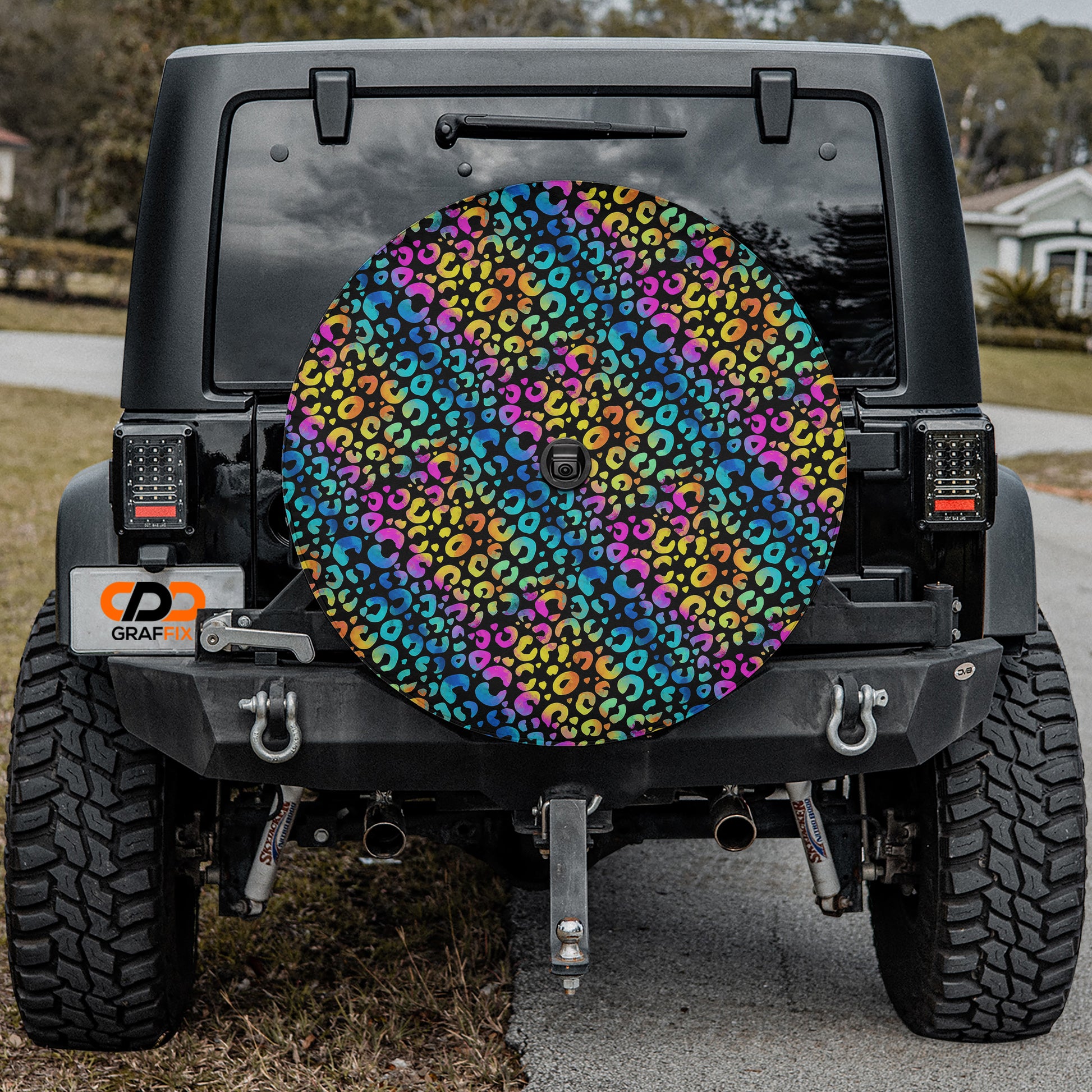 the rear of a black Jeep Wrangler with a colorful, leopard print wheel cover attached to the vehicle.