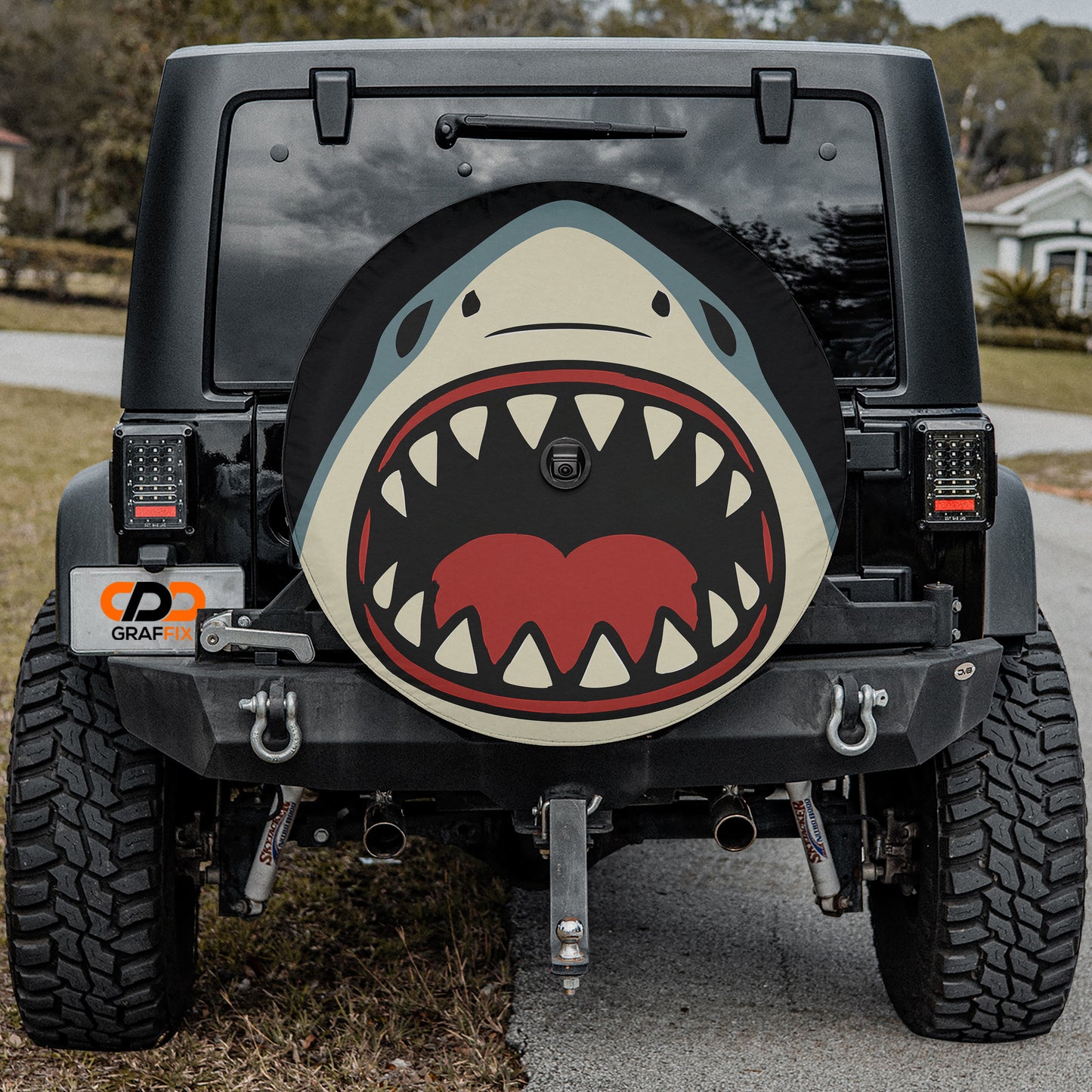 the back of a black Jeep Wrangler with a large shark decal on the rear window.